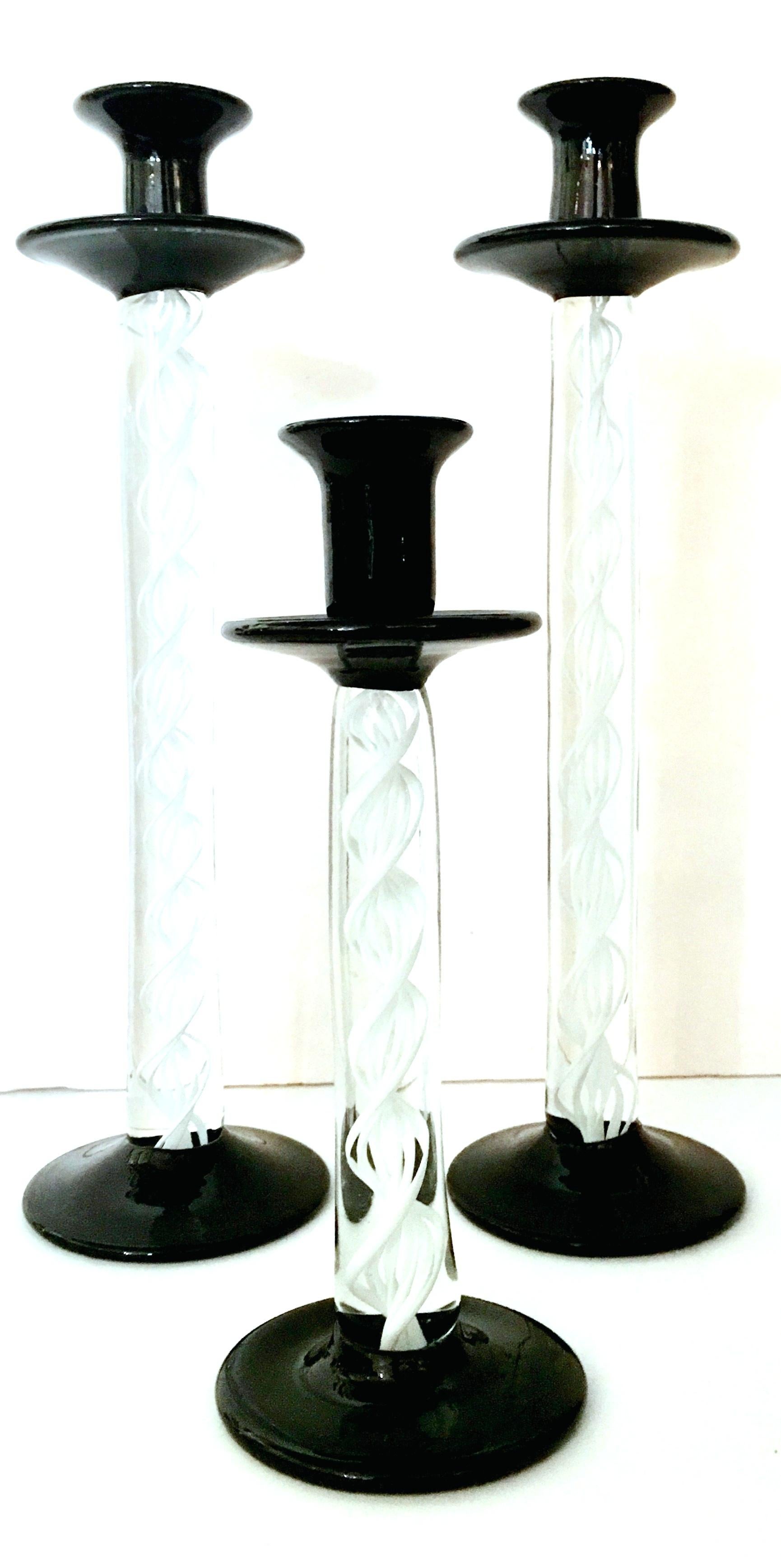 1980'S Italian Murano glass candlesticks set of three pieces. Features a translucent body with white cased swirl detail and black foot and holder. Small candlestick measures, 9.5