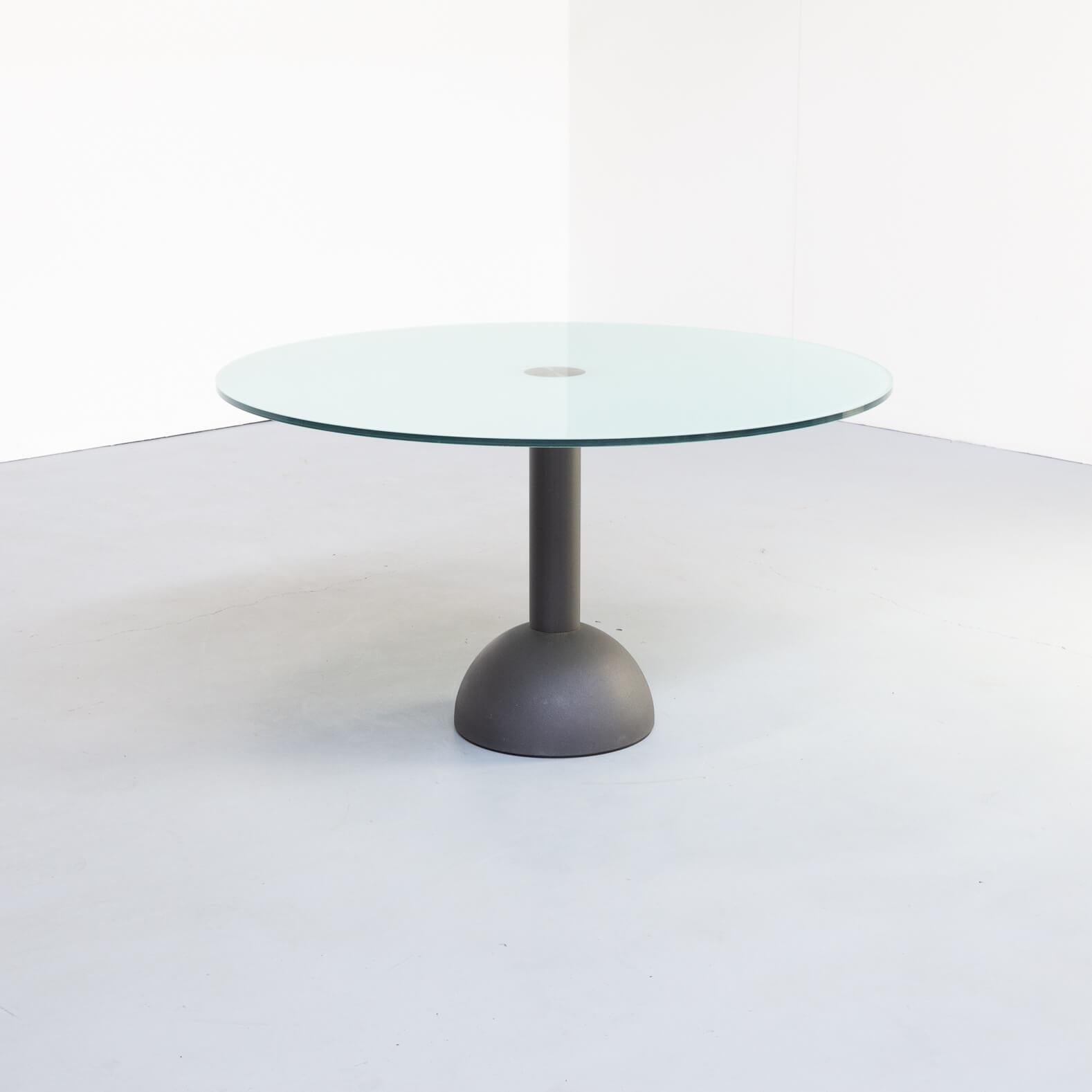 Beautiful 1980s design by Massimo and Lella Vignelli for Poltrona Frau. Firm round dining table on a cast iron foot with glass tabletop. Good condition consistent with age and use.