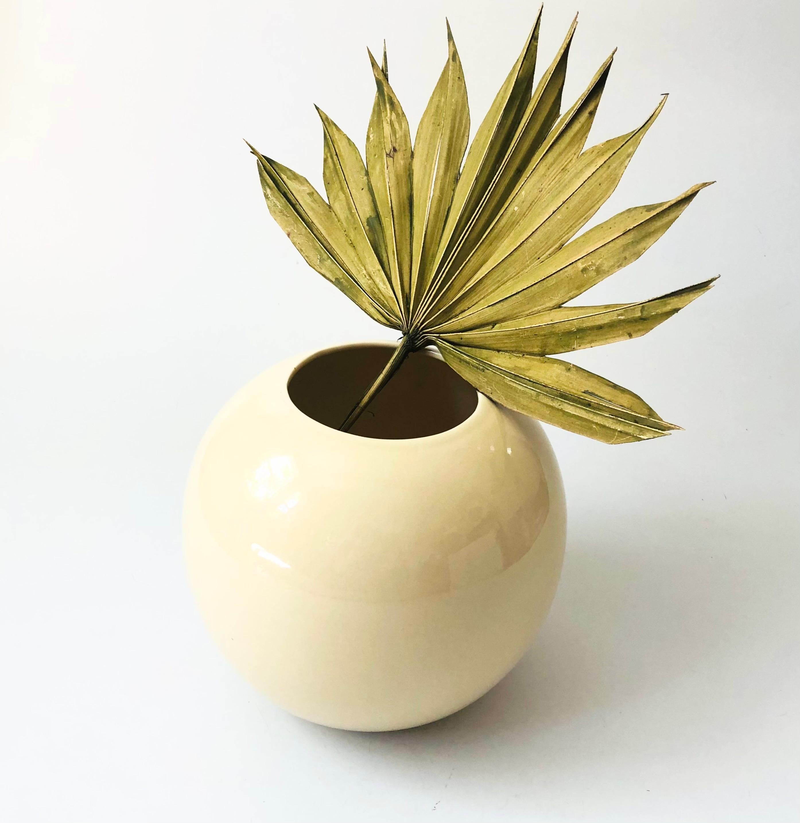 A vintage 80s ceramic vase. High gloss cream glaze in a simple modern sphere shape.

