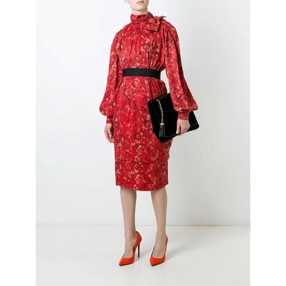 Nina Ricci red silk dress with black and beige print. Raised collar with decorative bow and back zip closure. Multi-layered design and puff sleeves with buttoned cuff.

Size: 44 FR

Flat measurements
Height: 108 cm
Bust: 70 cm
Shoulders: 38