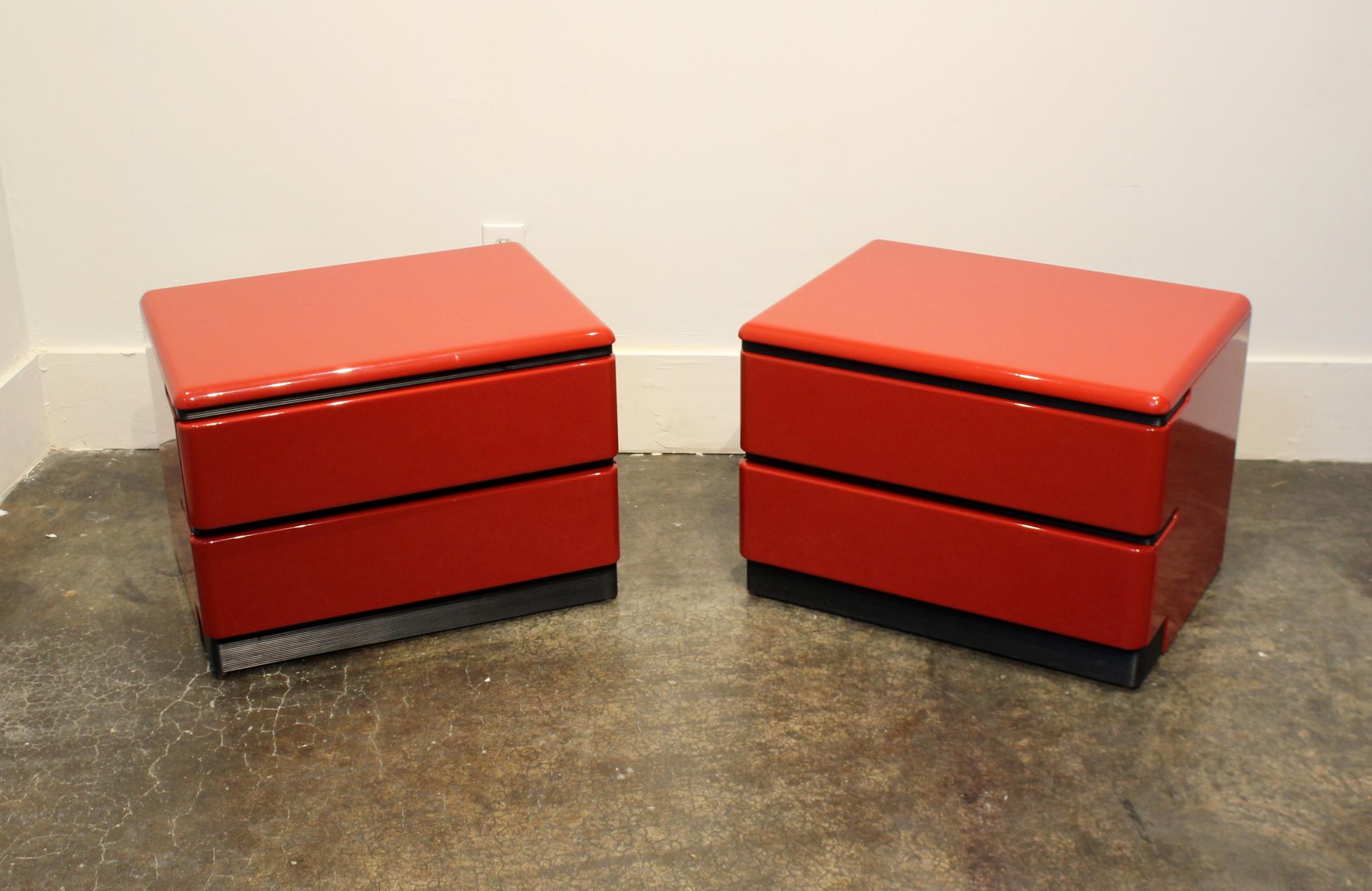 Lacquered red nightstands with black-ribbed accents and pulls by Canadian manufacturer and 1980s design icon, Roger Rougier. Both in very good condition with minor wear.