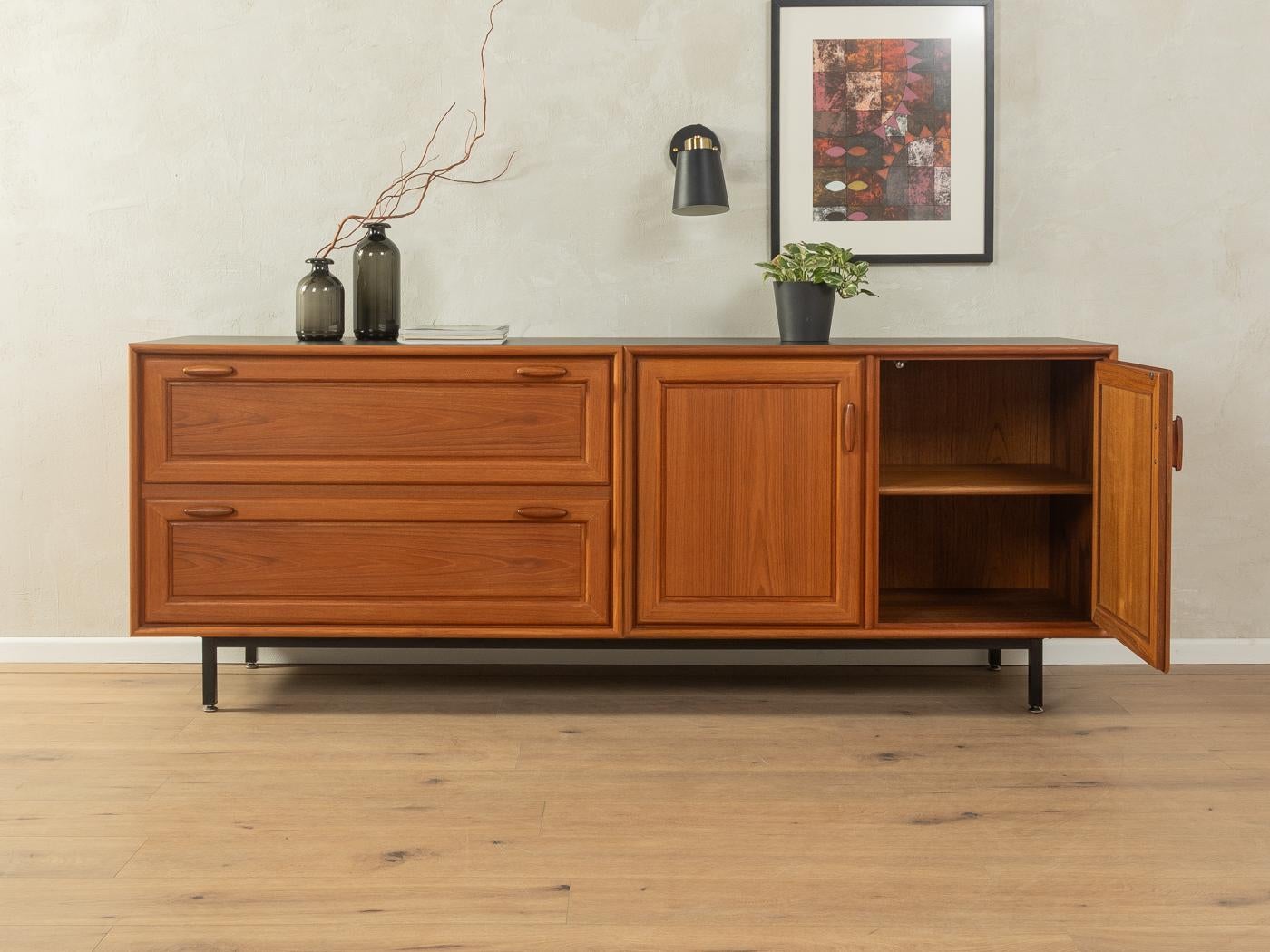 Credenza classica degli anni '1980. Corpo di alta qualità in impiallacciatura di teak con due cassetti, due ante, un ripiano e nuovi piedi quadrati in acciaio nero. Il piano è rivestito di Formica nera.

Caratteristiche di qualità:
ottima