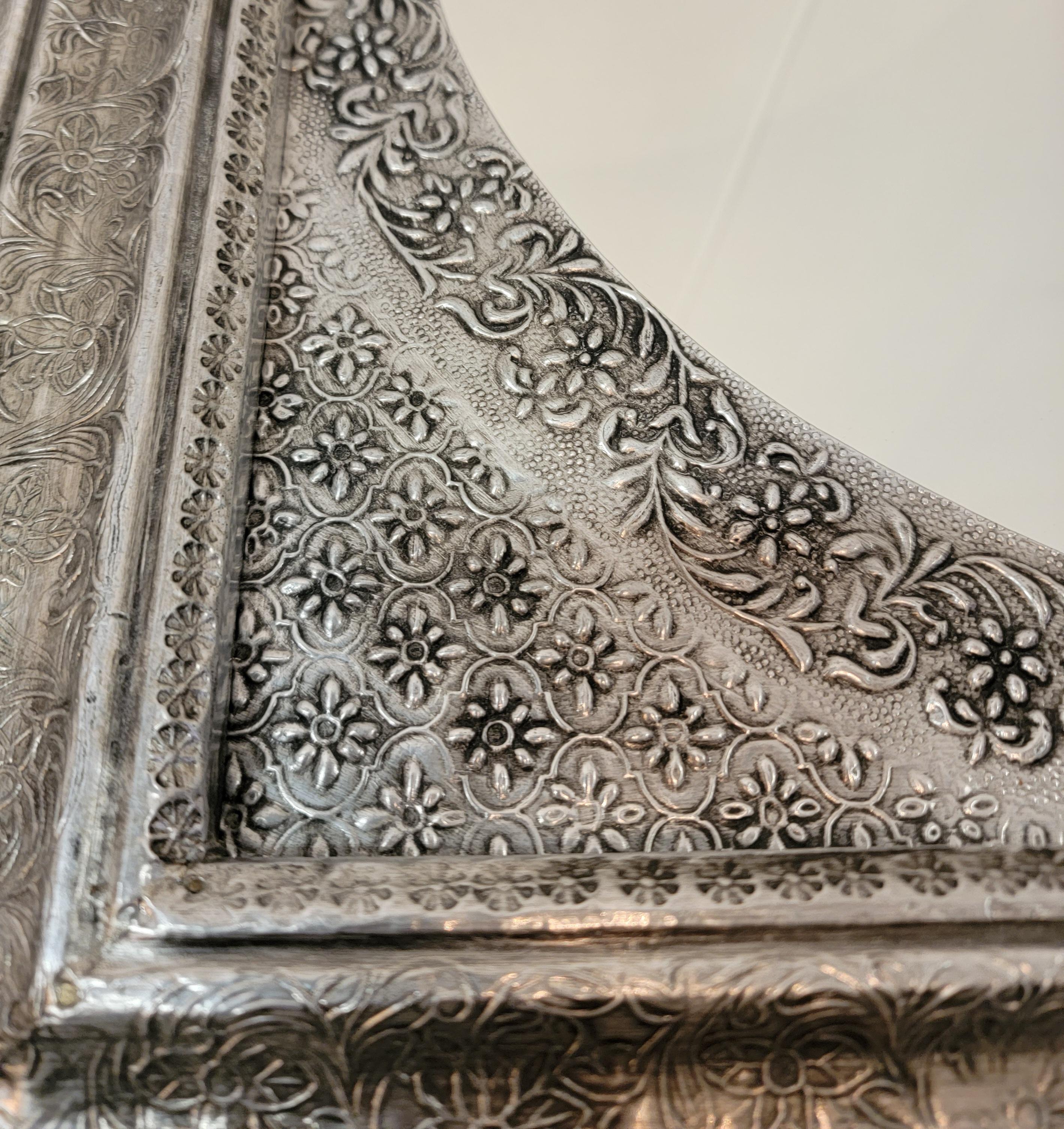 80s Silvered Square Mirror w/ivy Motif. The silver bend and contours around the edges of the wooden frame to make a snug fit. Very well done. The ivy motif flows throughout the entire silvered frame. Possibly hand hammered into place.