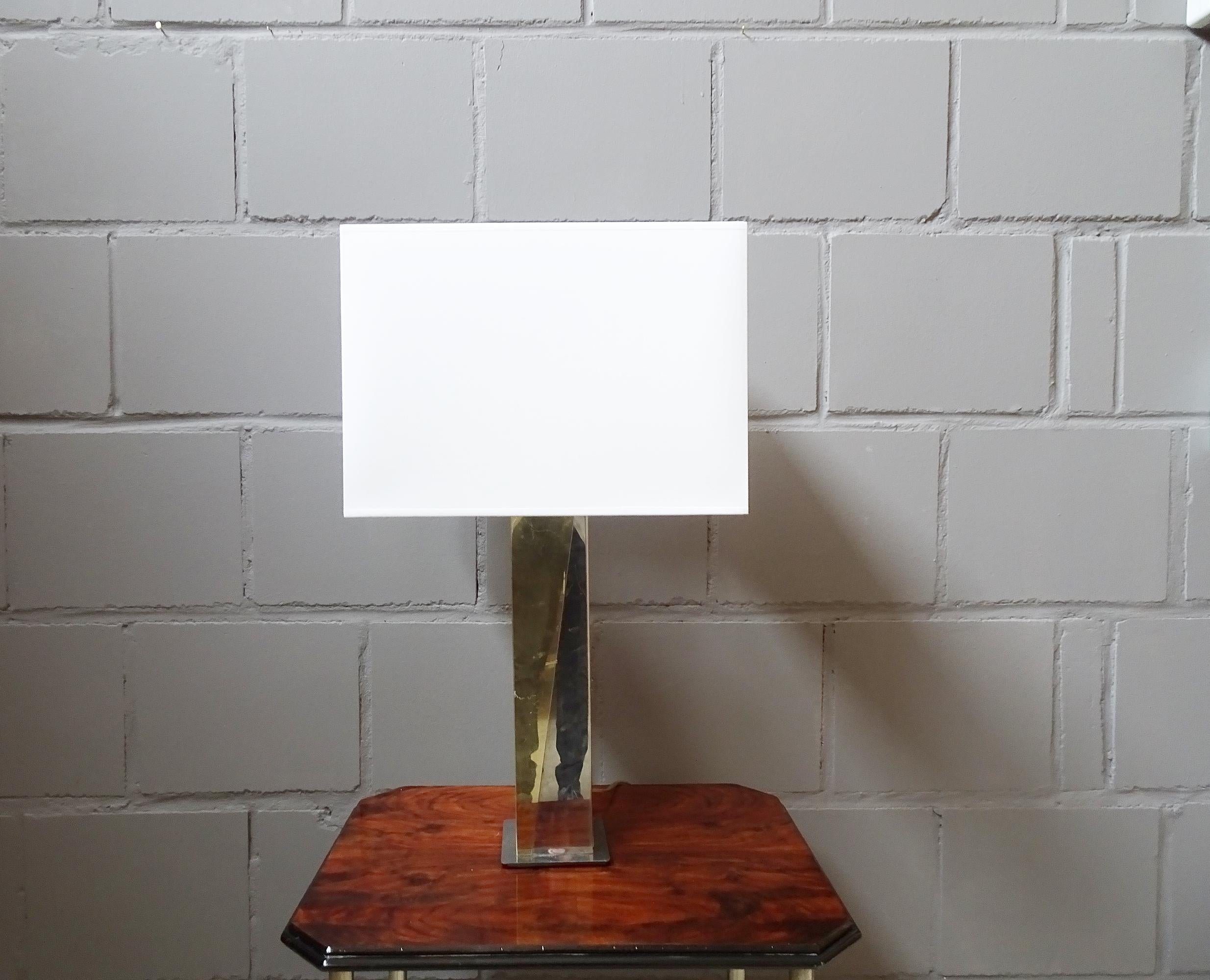 Large modernist table lamp made of gold and silver colored metal. Stylish design from the 1980s in the style of Willy Rizzo or Romeo Rega. Reflective metal in a design typical of the time in a long square shape. The lamp looks sculptural and is a