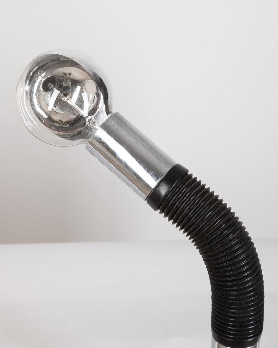 Table lamp applicable by means of a clamp, flexible arm in chromed metal and black plastic.
Periscopio model, Targetti design, 1980s. The light bulb shown in the photo is included.

Conditions: In excellent condition, working, it may show slight