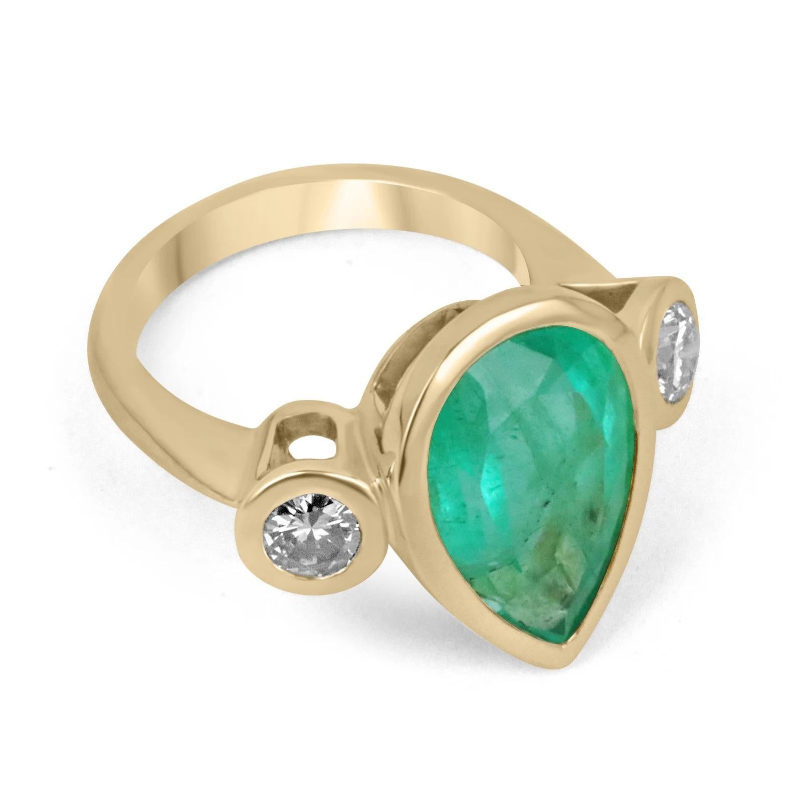 Displayed is an impressive vivid large emerald & diamond three-stone ring in 18K yellow gold. This one of a kind solitaire ring carries a pear emerald in a secure bezel setting. Fully faceted, this rare gemstone showcases good shine and brilliance.