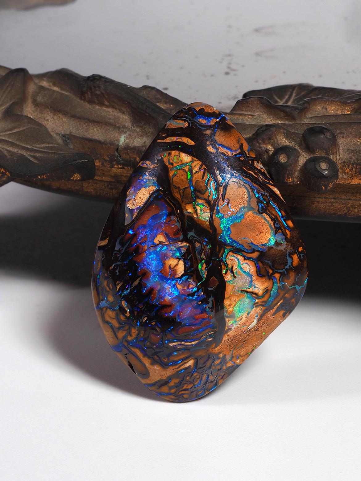 This exceptional boulder Koroit Opal is a true masterpiece of nature, showcasing a captivating array of colors and patterns. Mined from the Australian outback, this opal's unique shape and vibrant hues make it a rare and striking gemstone. Weighing