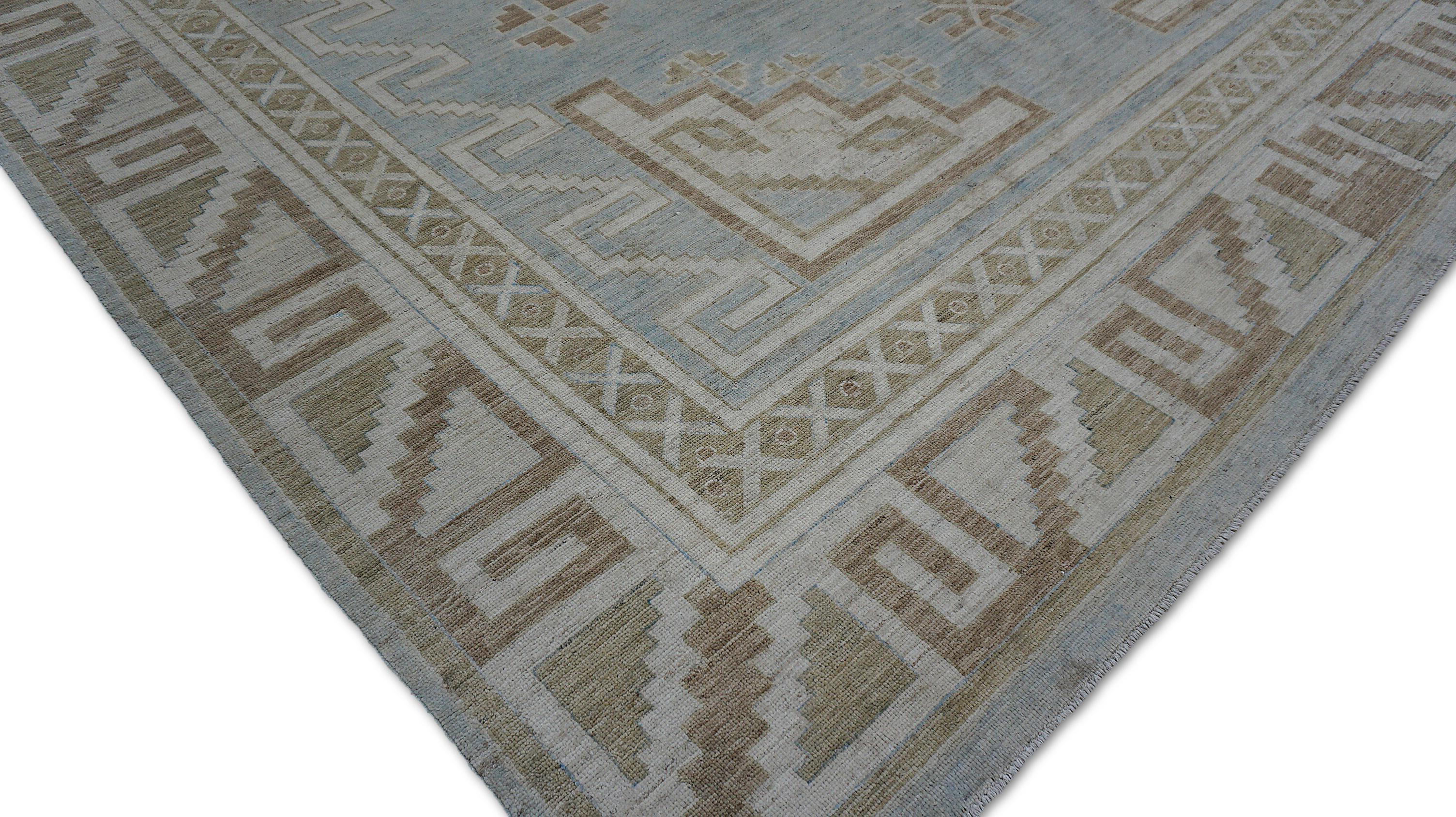 Esta elegante alfombra Oushak anudada a mano presenta un sereno campo azul cielo enmarcado por un llamativo borde geométrico, que refleja los diseños intemporales de las tradiciones tejedoras de Anatolia. El medallón central y los motivos que lo