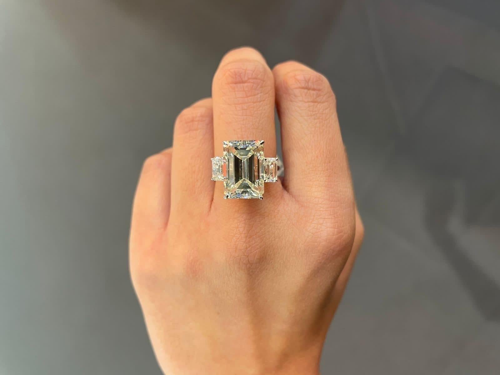 Make a statement with this stunning 8.10 carat emerald cut natural Diamond three-stone engagement ring. The center stone weighs 8.10 carat, K color, VS1 quality, with two smaller emerald cut diamonds next to it - all set in solid 18K white gold.