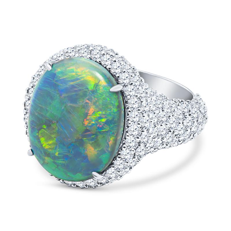 This very unique ring features a 8.13 carat oval cut double cabochon Australian Lightning Ridge opal accented by 4.69 carat total weight in fine natural pave-set round diamonds. It is set in platinum. It is a beautiful ring that will shine from