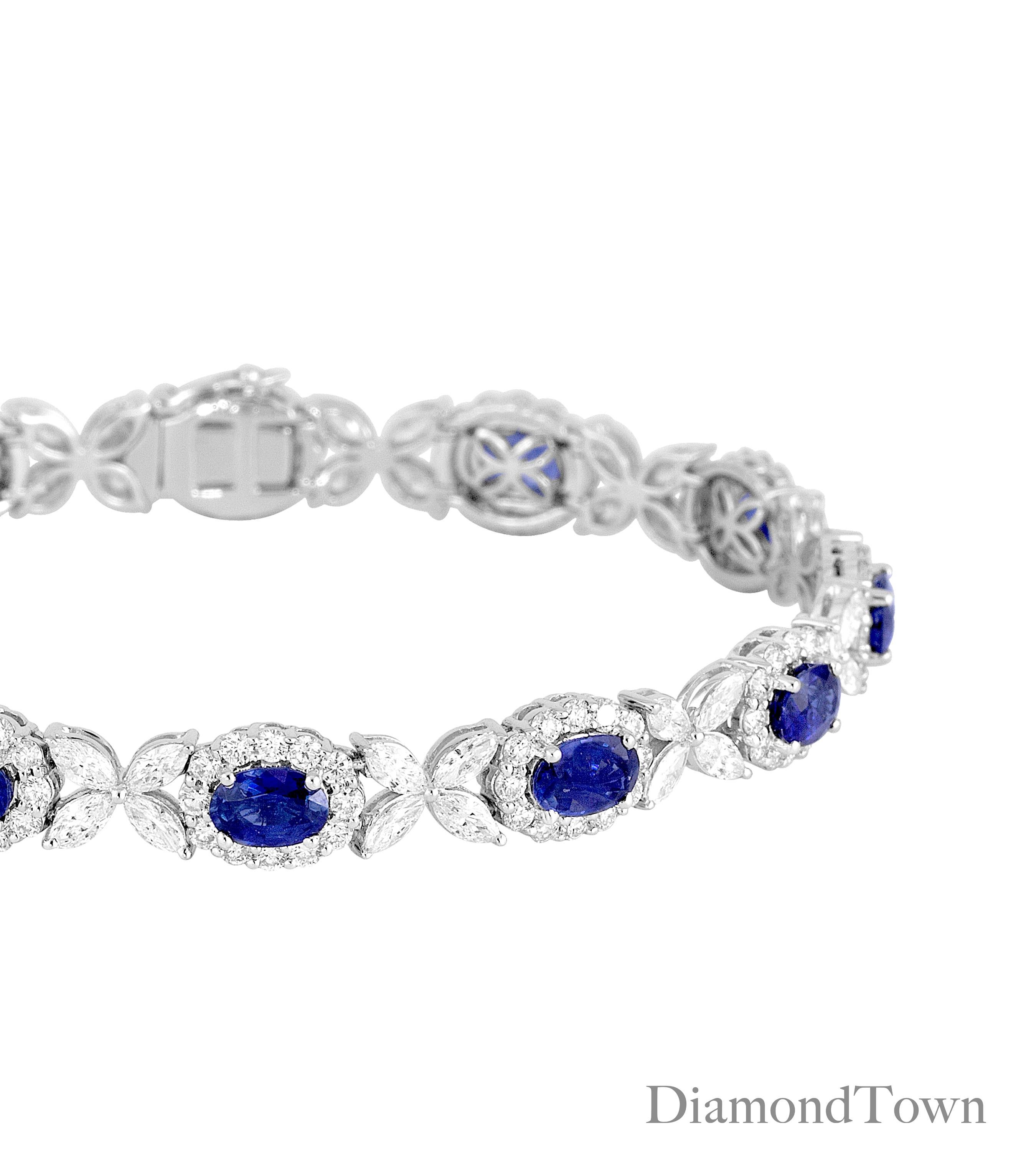 This bracelet features 11 Oval Cut Vivid Blue Sapphires (total weight 8.14 carats), each in a halo of round diamonds, and alternating with flowers of marquise cut diamonds. The total diamond weight is 6.95 carats.

Bracelet measures 7