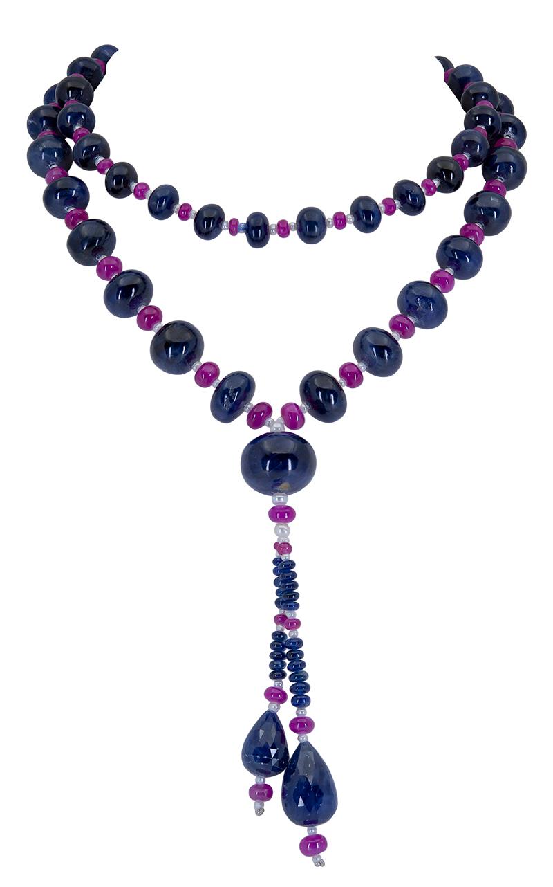Showcasing a row of sapphire beads spaced by small rubies in-between. Dropping from the necklace are two semi-pear shape beads. 
31 inch length.
4 inch drop.
