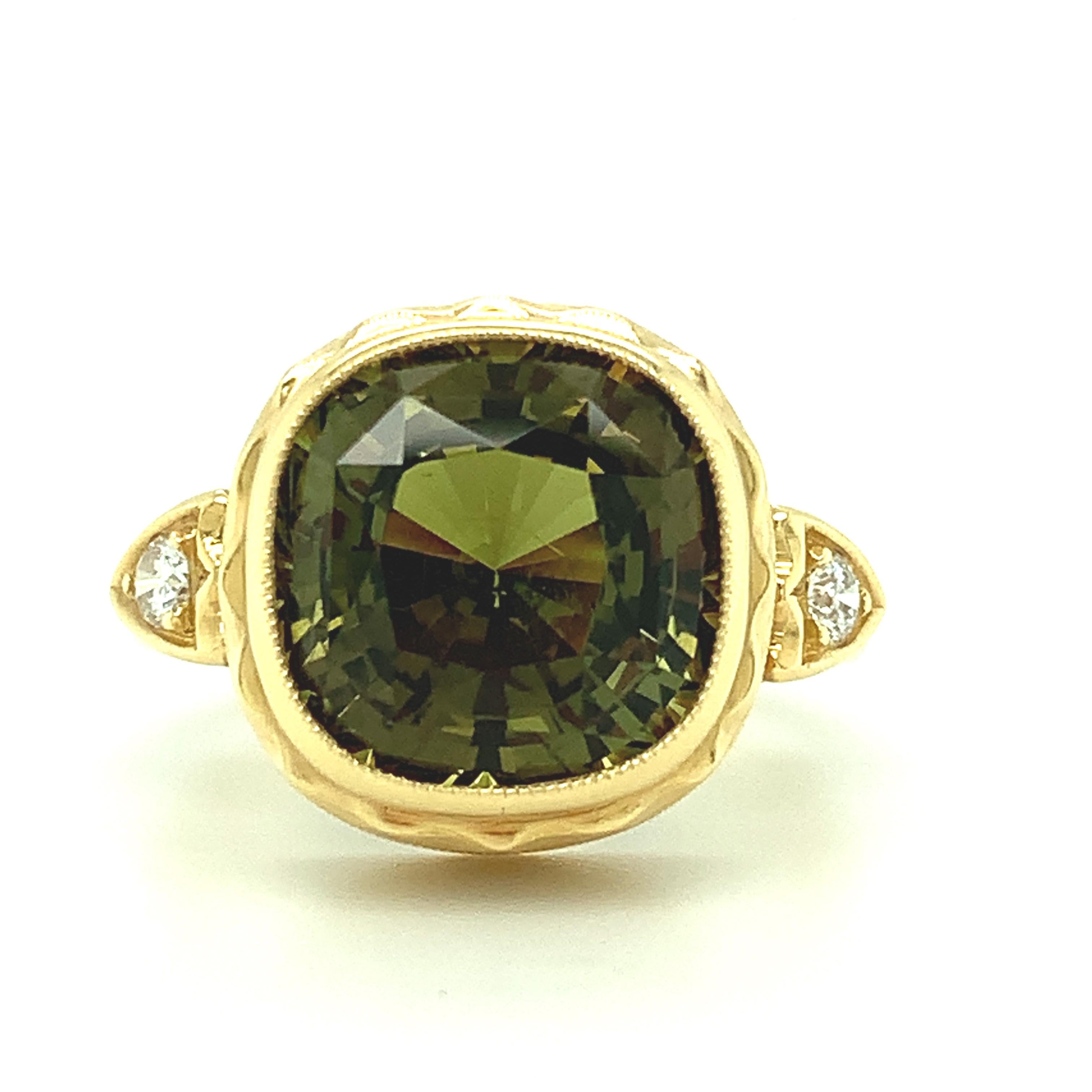 This handmade 18k yellow gold ring features a beautiful 8.16 carat, cushion cut chrysoberyl with extraordinary brilliance and life! The ring was designed to showcase this gorgeous gem, whose sparkling facets reflect a blend of striking olive green