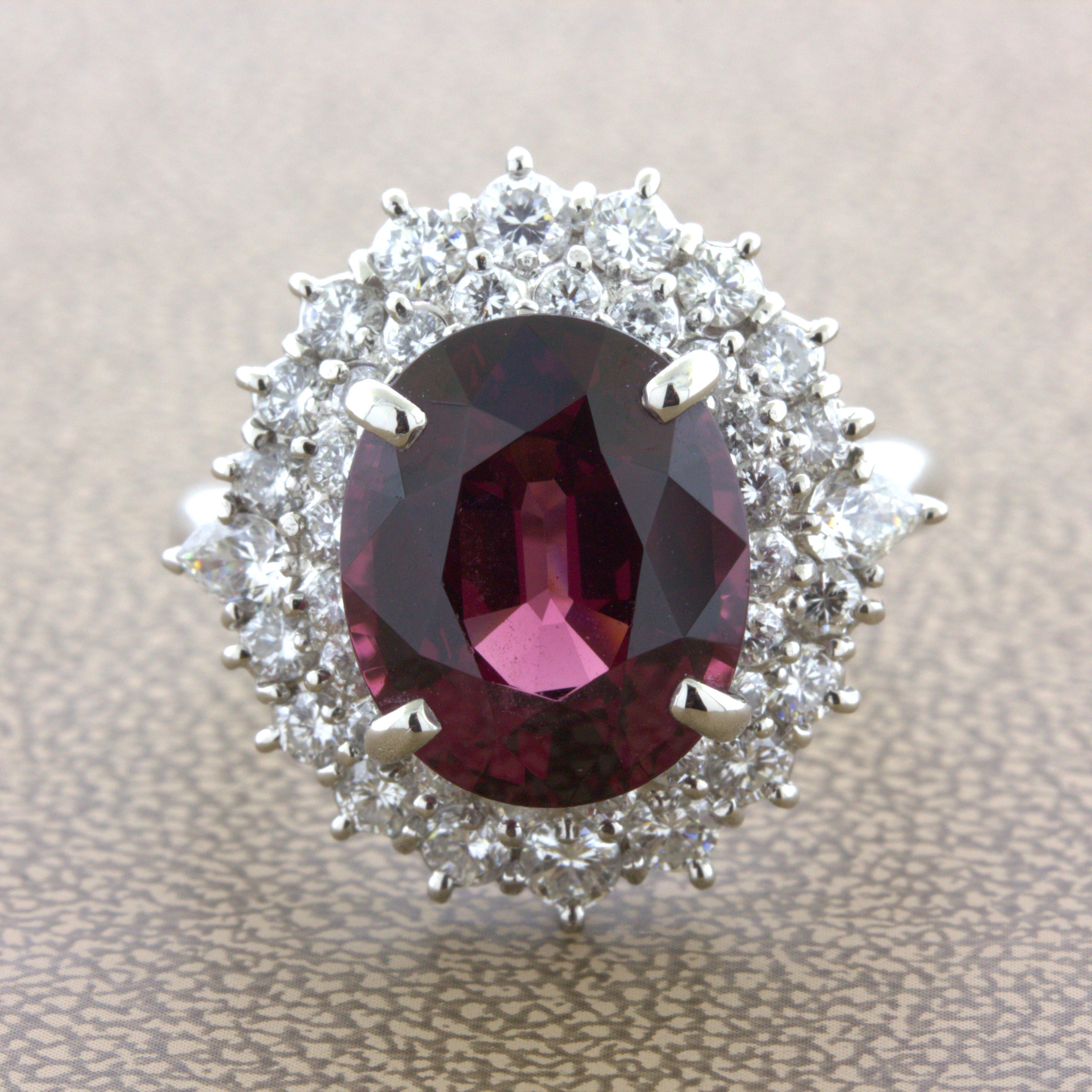 A super gem garnet, rhodolite variety, takes center stage! It weighs an impressive 8.16 carat and has an intense rich red color with secondary purple color making the stone glow. It is complemented by 1.58 carats of round brilliant-cut diamonds