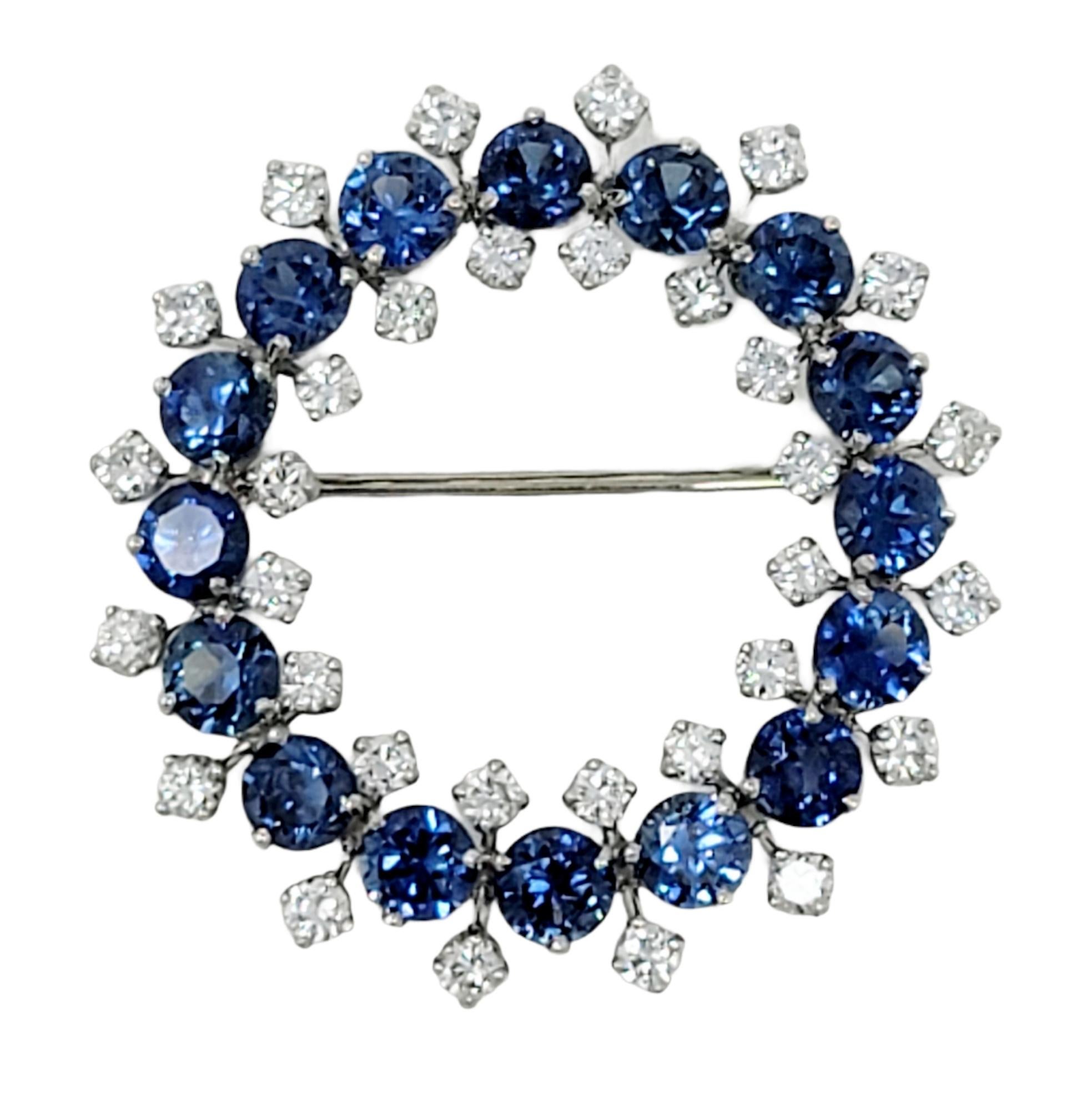 Exquisite blue sapphire and diamond brooch bursting with sparkle. Pair on a scarf, sweater, jacket or bag for an undeniably glamorous touch. This gorgeous brooch features 18 round cut natural blue sapphire stones prong set in an open circle design