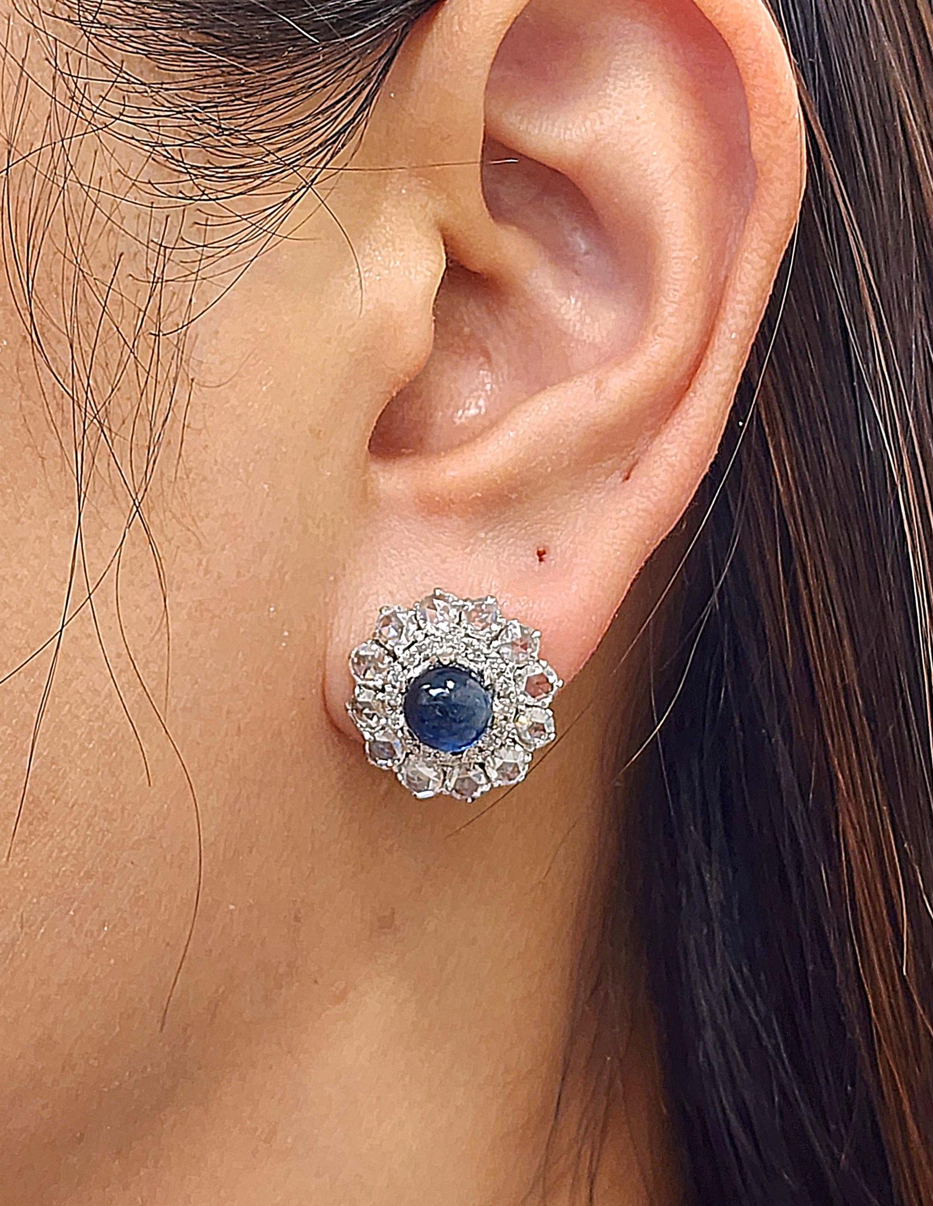 Super unique natural cabochon sapphire and diamond earrings features 2 cabochon sapphires weighing 4.87 ct. The sapphires are surrounded by 56 rose-cut diamonds weighing 3.32 ct set in 18k white gold. They boast a color of F/G, and VS2/SI1 in