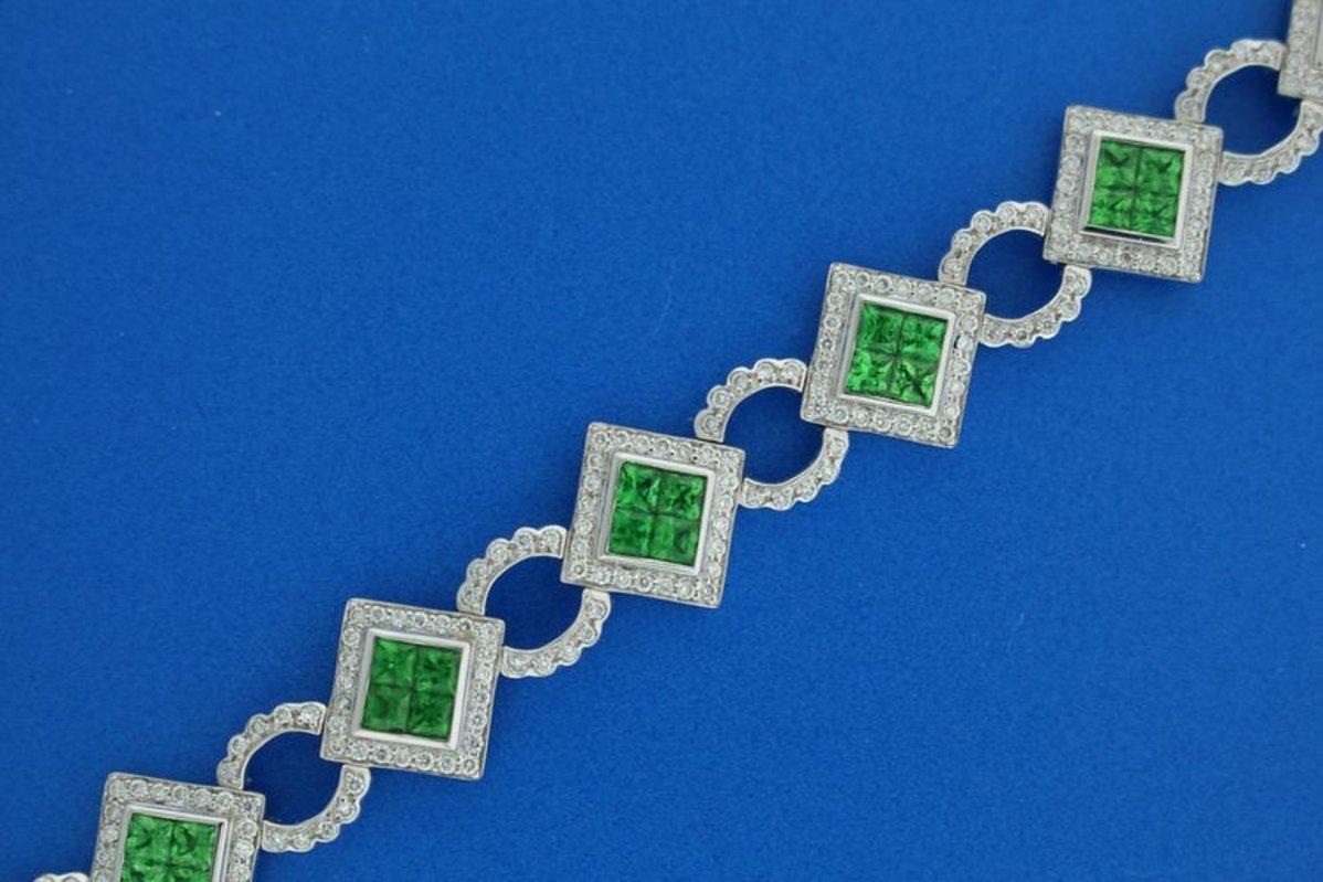 Ce superbe bracelet en tsavorite et diamant blanc présente 11 grappes de tsavorites vertes (5,39 carats), comprenant chacune 4 tsavorites vertes de taille princesse dans une monture invisible entourée de diamants blancs ronds et attachées par des