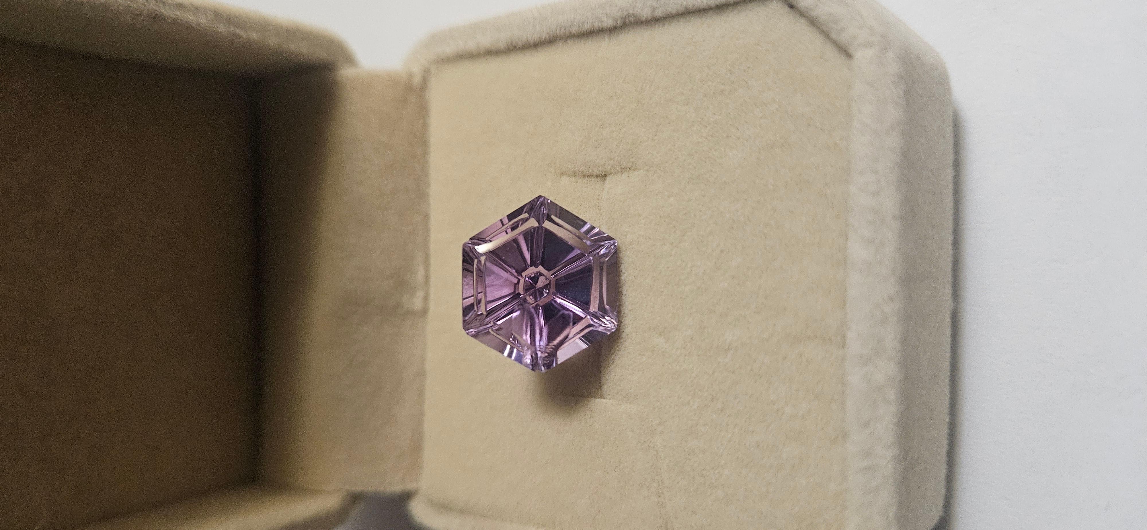 The product is an 8.2 carat natural Brazil amethyst hexagon fantasy cut gemstone, measuring 13x13mm. This stunning gemstone is created naturally in Brazil, showcasing a unique hexagon shape that adds a touch of elegance to any jewelry piece. Perfect