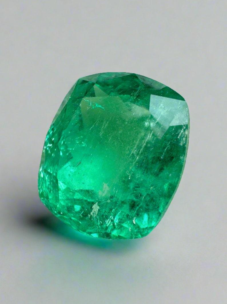 Stone: Emerald
Weight: 8.20-carats
Shape: Cushion Cut
Clarity: Transparent
Luster: Excellent
Color: Muzo Green
Measurements: 13.36mm x 11.52mm x 8.43mm
Geographic Origin: Colombia
Treatment: Natural, Oiling

Comments: Due to their growth conditions
