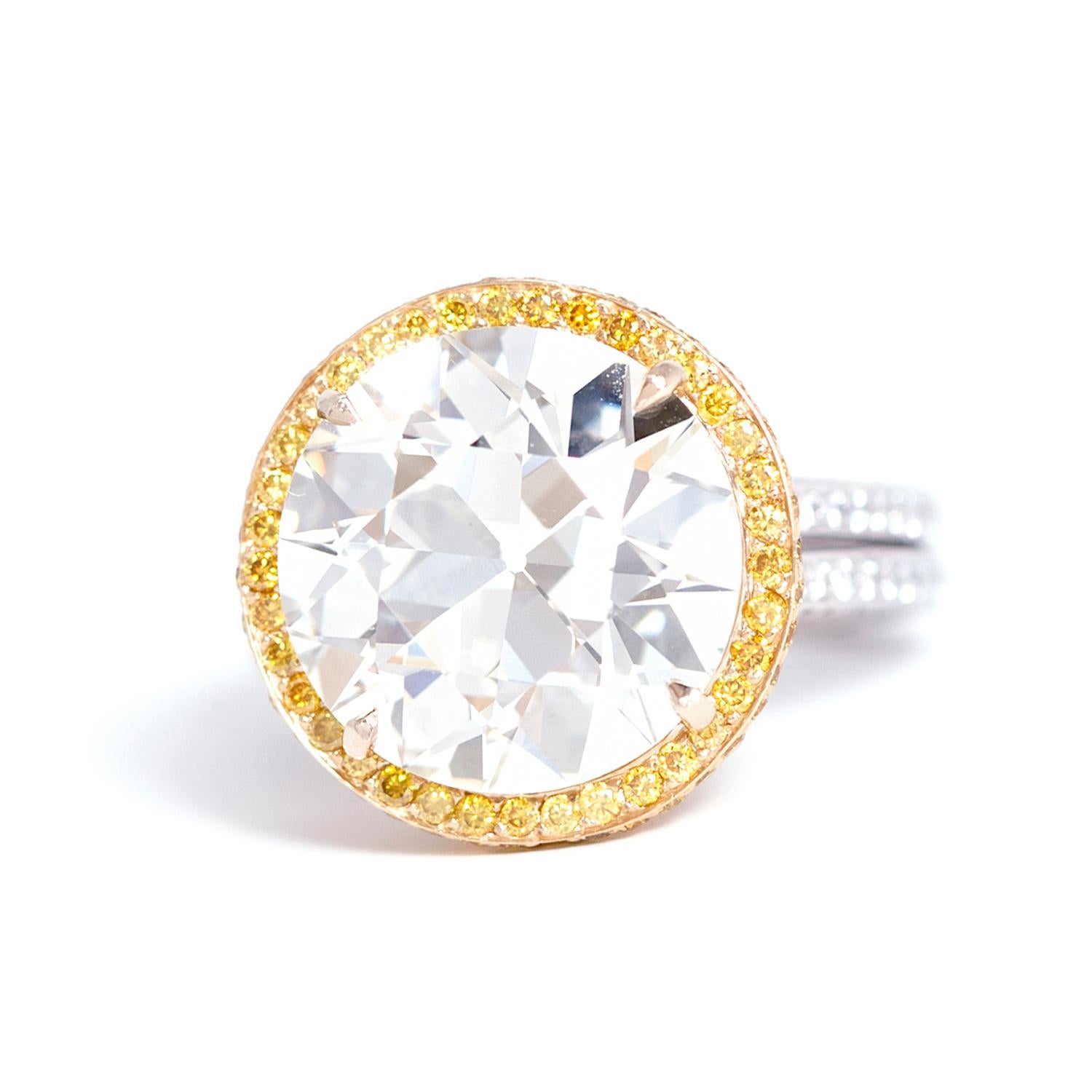 This platinum and 18 karat gold ring features a 8.22 carat old European cut diamond (K color VVS clarity, no certificate).
the top is set with approximately 0.80ct yellow round diamonds and the shank is set with approximately 0.80ct white round