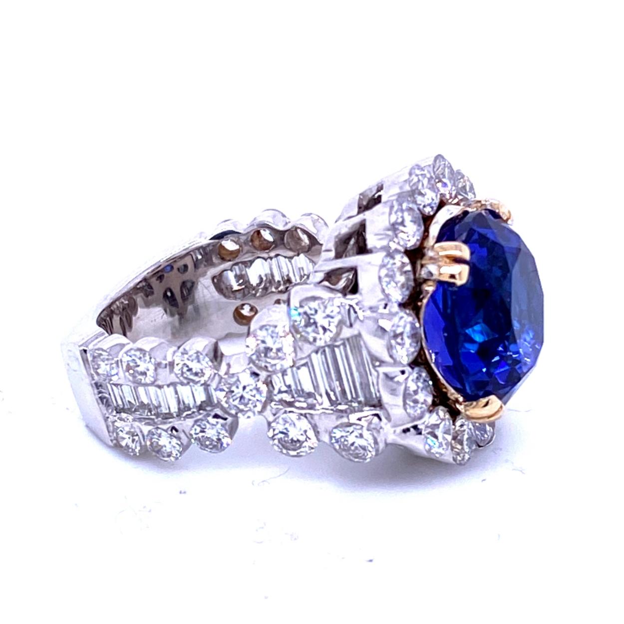 A beautiful color 8.23 Ct Round shaped Tanzanite (looks like Sapphire) set in the center of an 18K Square Shank Invisible set (you see no metal) Diamond Engagement Ring. 

Details:
Center Stone: 8.23 carat Round Tanzanite - 12.5 mm
Side Stone