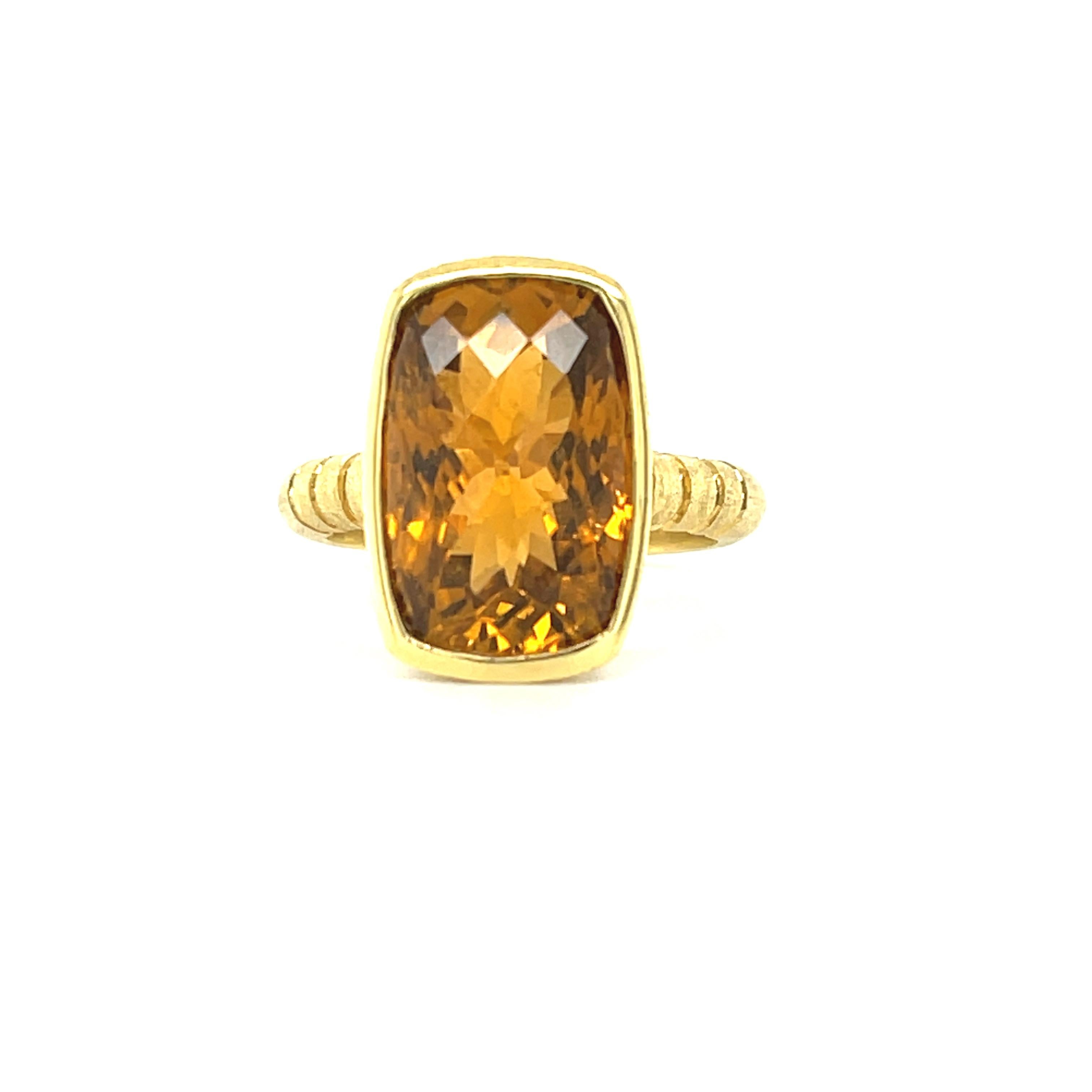 This elegant and sophisticated ring was custom-made in 18k yellow gold to showcase a beautiful 8.24 carat golden tourmaline. The center gemstone is a cushion-shape, whose crown has been faceted with a fancy checkerboard pattern for exceptional
