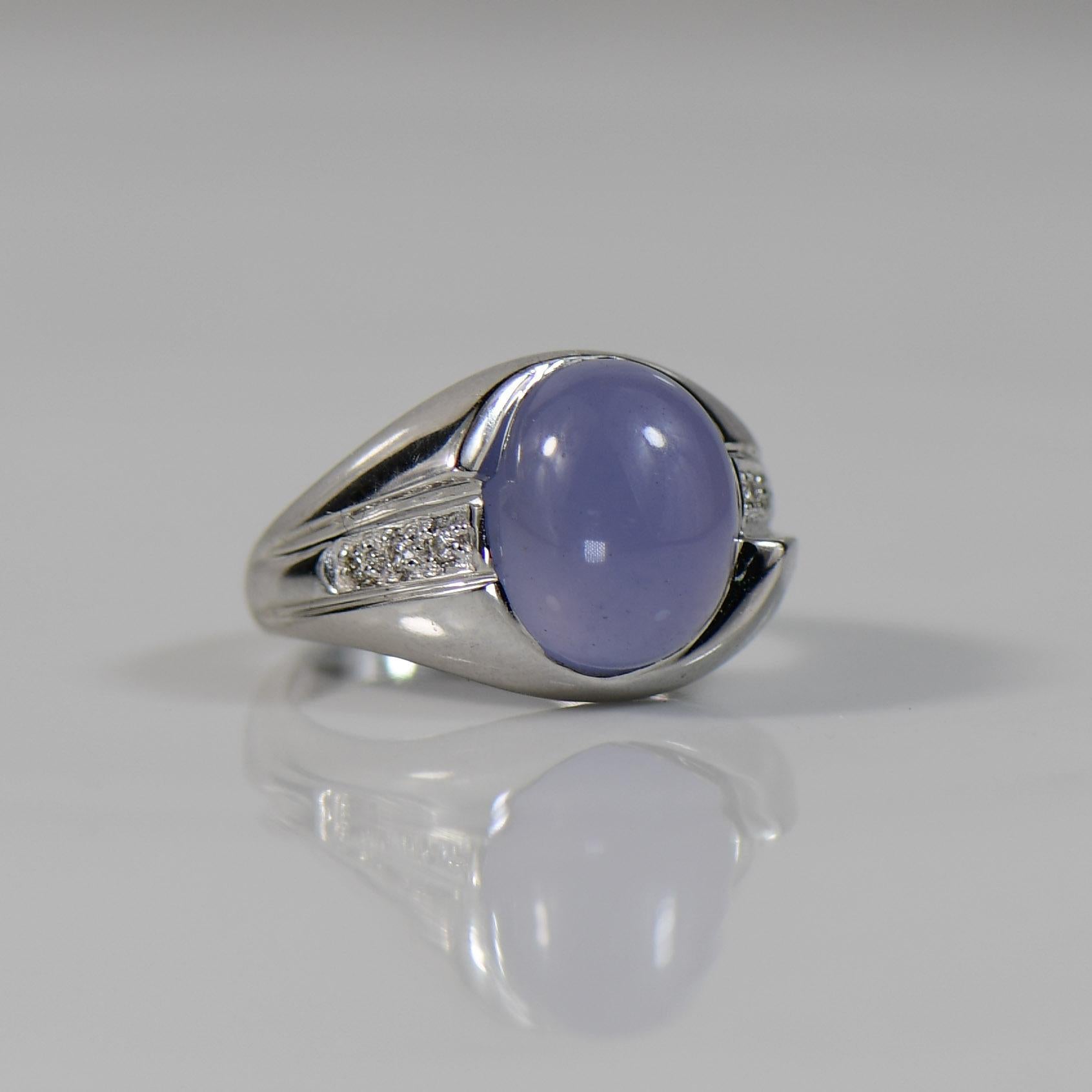 Set in lustrous 18K white gold, this stunning ring showcases a captivating Sapphire Cabochon at its center, its smooth surface emphasizing the rich, velvety hues of the precious gemstone. Framed by a delicate arrangement of diamonds, the ring