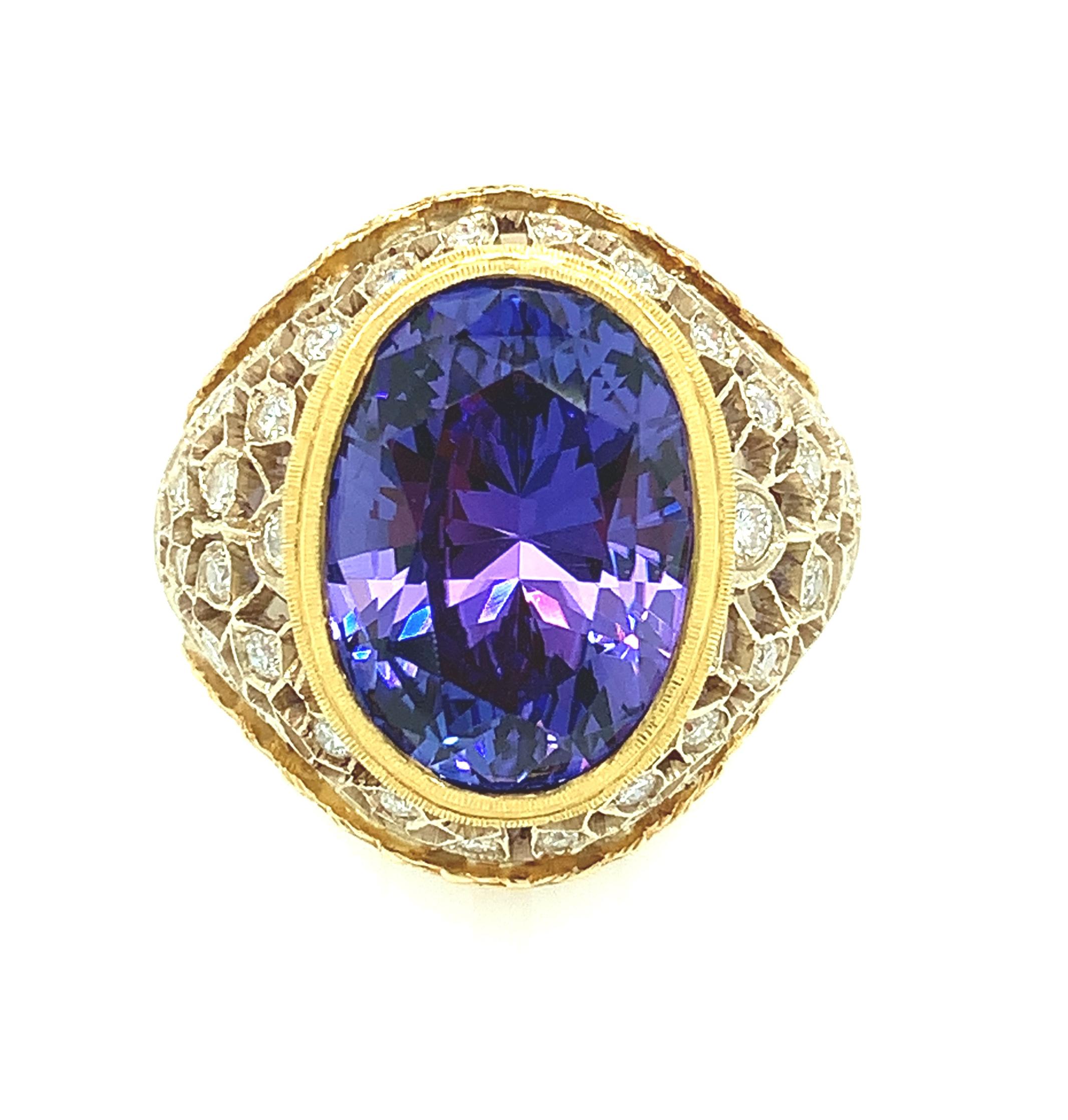 A deep, periwinkle blue tanzanite weighing 8.25 carats is featured in this beautiful Florentine inspired ring set with round brilliant cut diamonds. The intricately pierced and engraved details of this ring display the skills required to create such