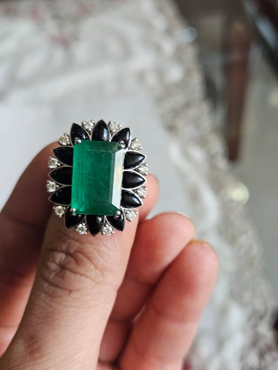 Un bellissimo anello di fidanzamento in stile moderno con smeraldo e onice nero, incastonato in oro bianco 18 carati e diamanti naturali. Il peso dello smeraldo è di 8.25 carati. Lo Smeraldo è completamente naturale, senza alcun trattamento ed è di