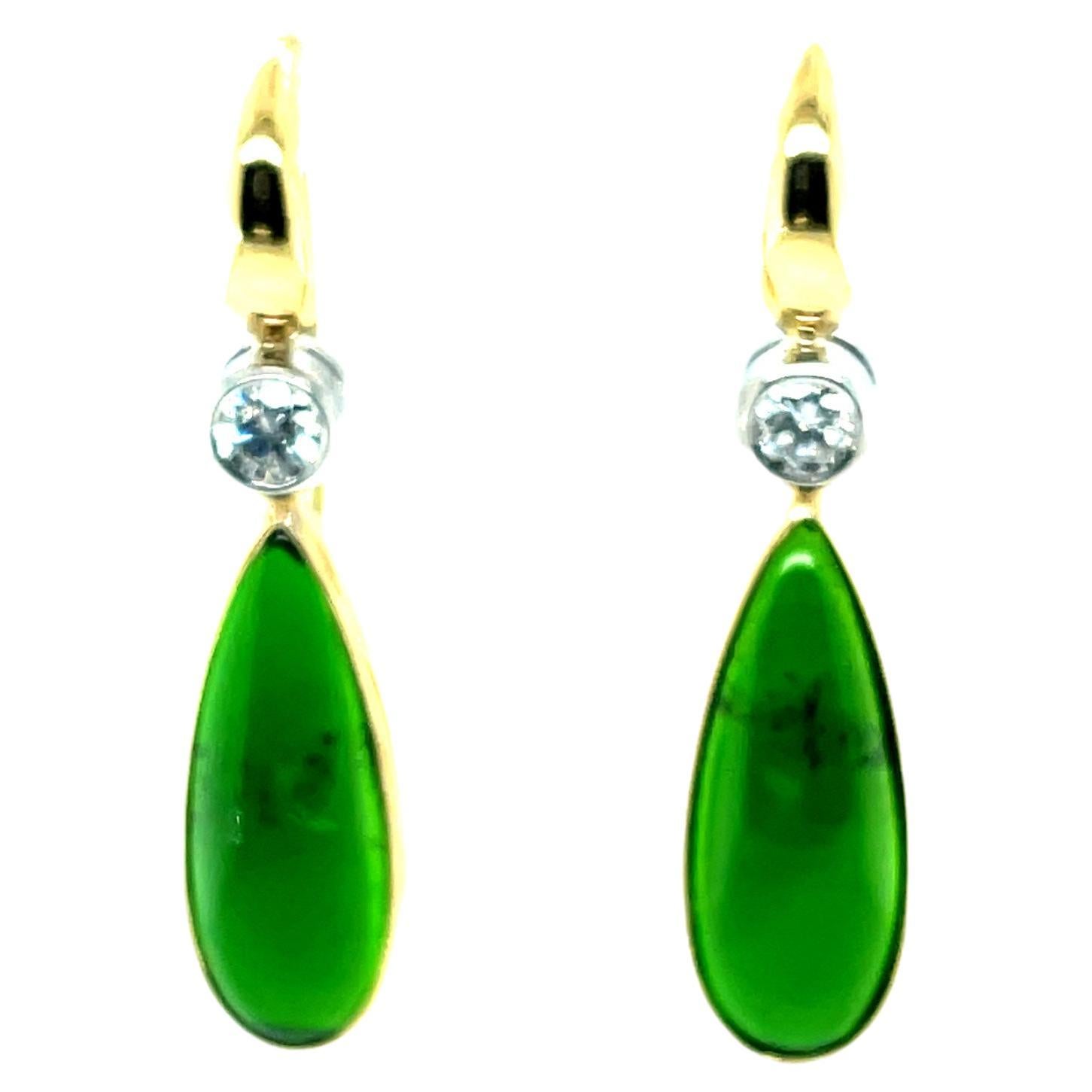 These lovely earrings feature a pair of beautiful chrome diopside cabochons set in 18k yellow gold bezels, dangling below sparkling diamonds set in white gold bezels. Fine quality chrome diopside is a rich, vivid green color and it is luxuriously