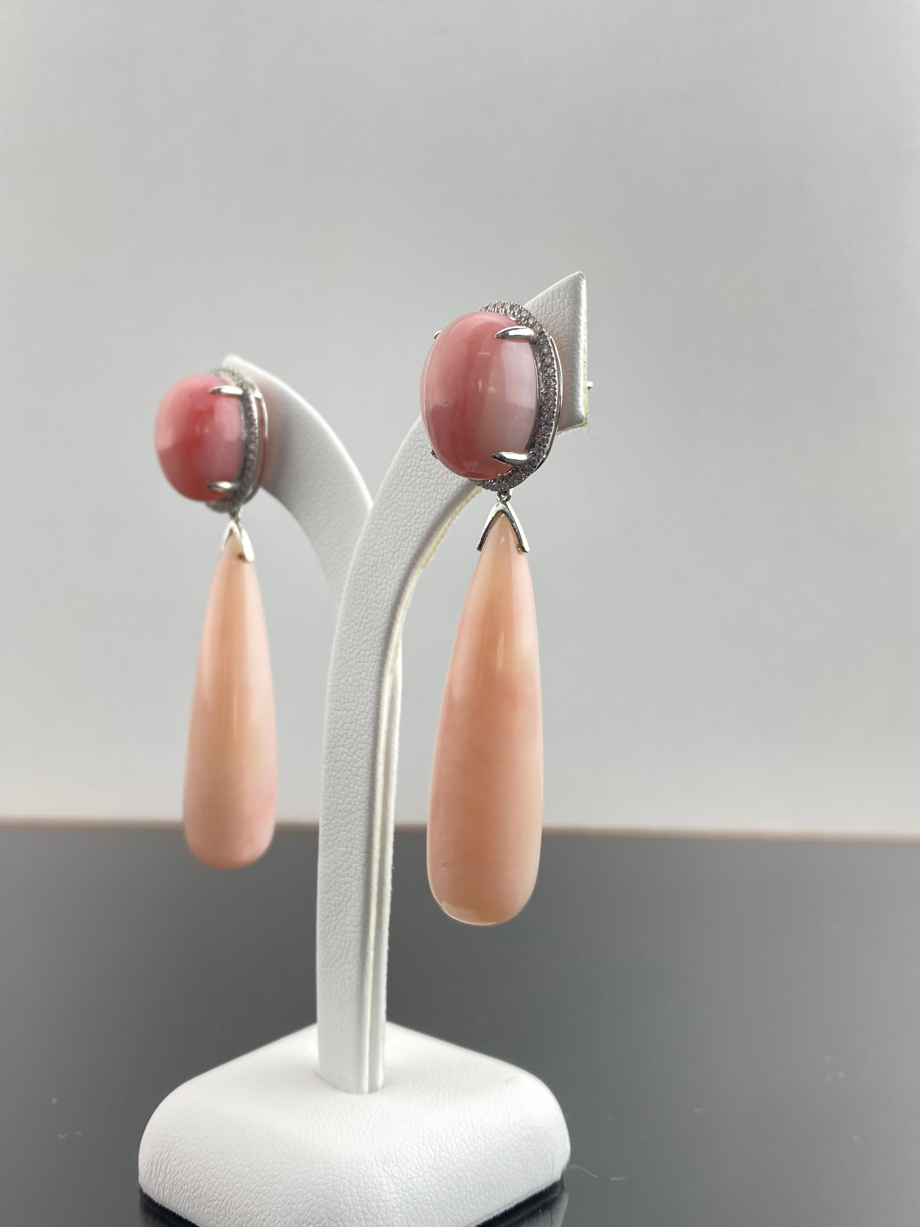 A beautiful pair of dangle earrings, with 18.64 carat oval cabochon Pink Opals and 63.97 carat drop shaped Pink Opals. Set in solid 18K White Gold, with 0.39 carat Diamonds. 

Details:
18K Gold Weight: 6.45 grams
Diamond: 0.39 carat                 