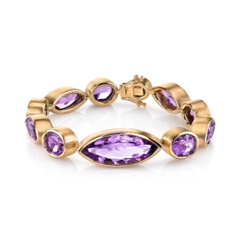 This custom designed, 18k yellow gold handmade tennis bracelet features 82.64 carats of bright, sparkling, marquise and oval amethysts! Each bezel has been handcrafted and brushed with an elegant velveteen finish by our Master Jewelers in Los