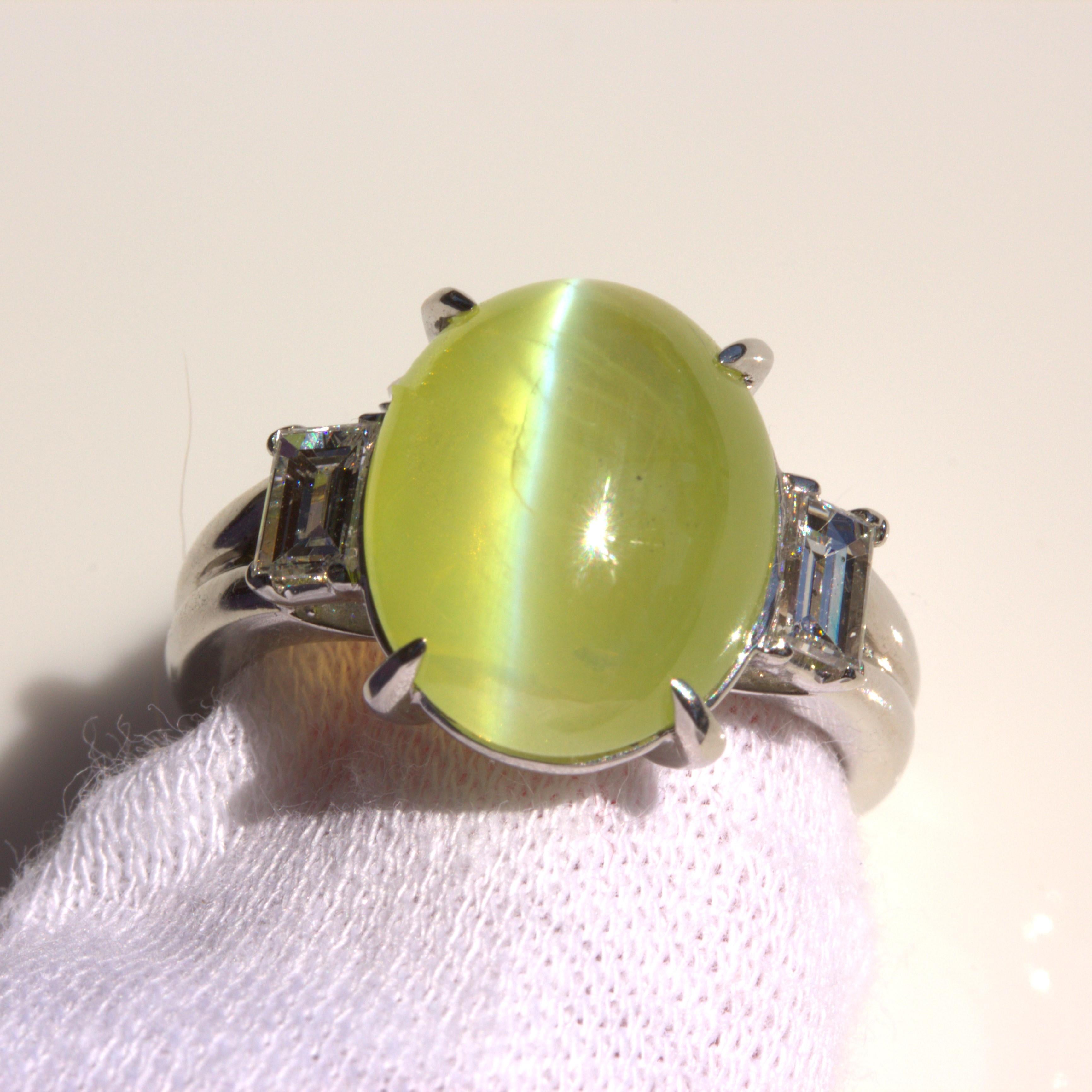 A classy and elegant platinum ring featuring a 8.27 carat cats eye chrysoberyl. Not only does the gem have a large size but it has very fine quality in its bright and open yellow-green color and its strong chatoyancy (cats eye effect). It is