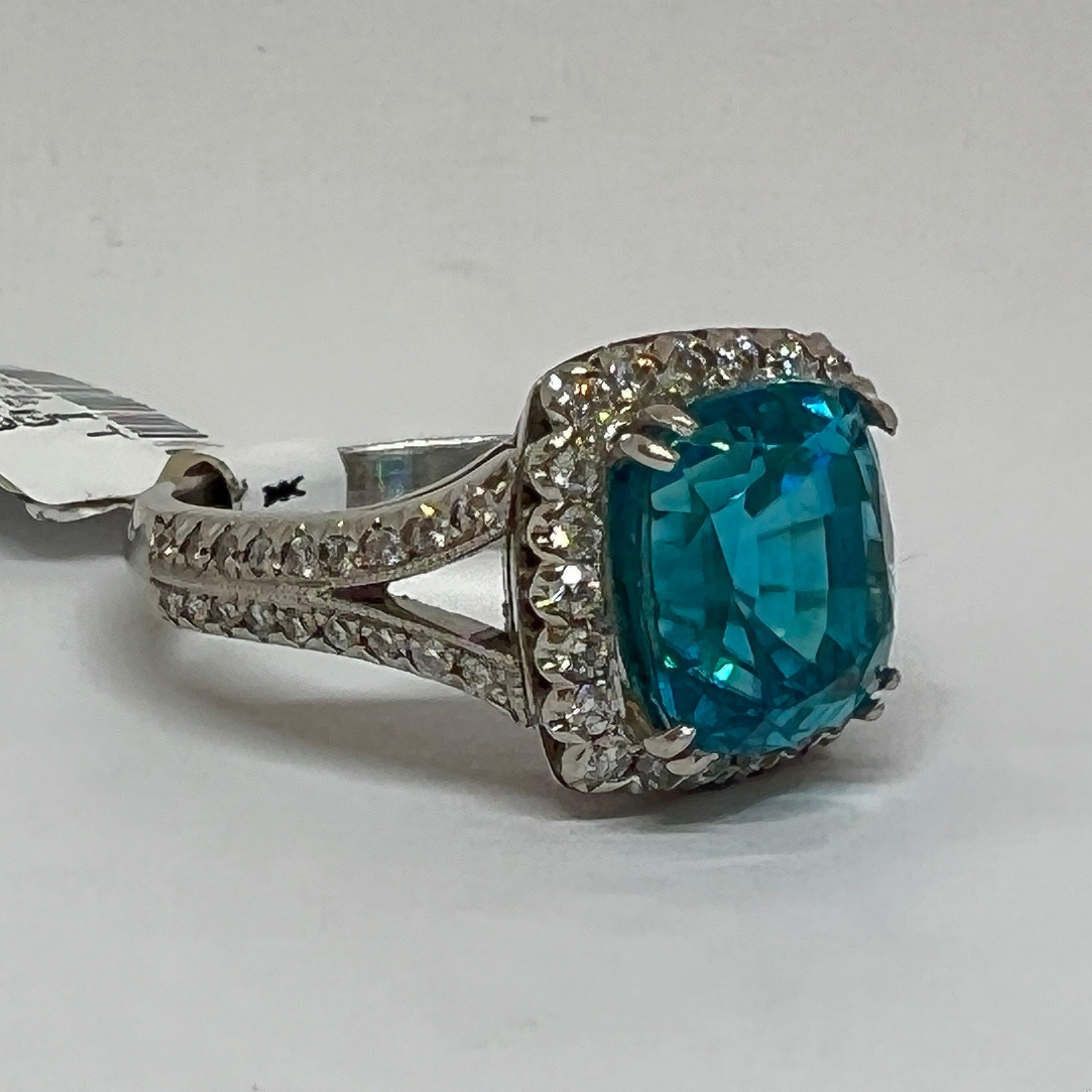 Hand fabricated by Mark Areias Jewelers in solid Platinum set with beautiful diamonds and a cushion shape natural blue zircon gemstone. The diamonds rate VS clarity, F-G color with a total weight of 0.70 carats. The lagoon colored blue zircon weighs