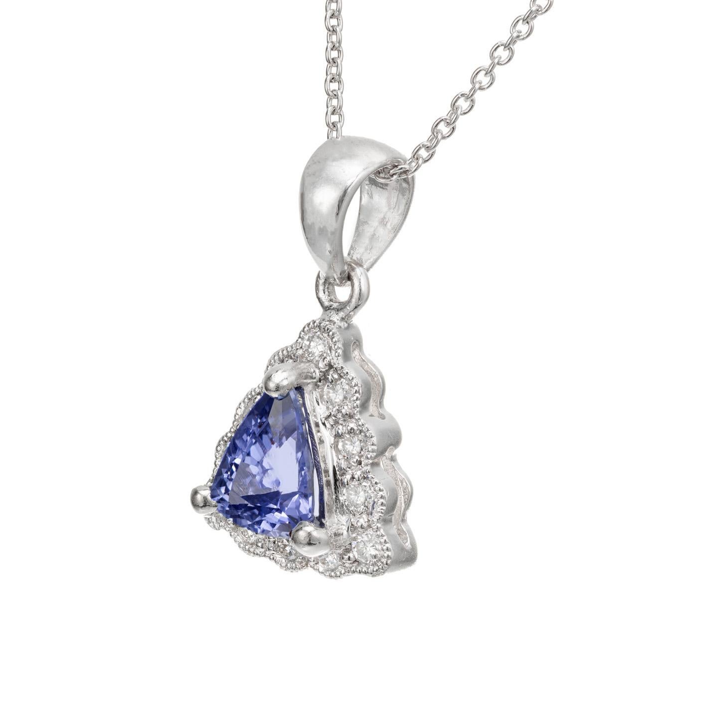 Tanzanite and diamond pendant necklace. Triangular shape tanzanite with a halo of round beaded bezel set diamonds set in Platinum with a platinum 18 inch cable chain. 

1 triangular Tanzanite .83cts
12 round diamonds approx. total weight .24cts, F,