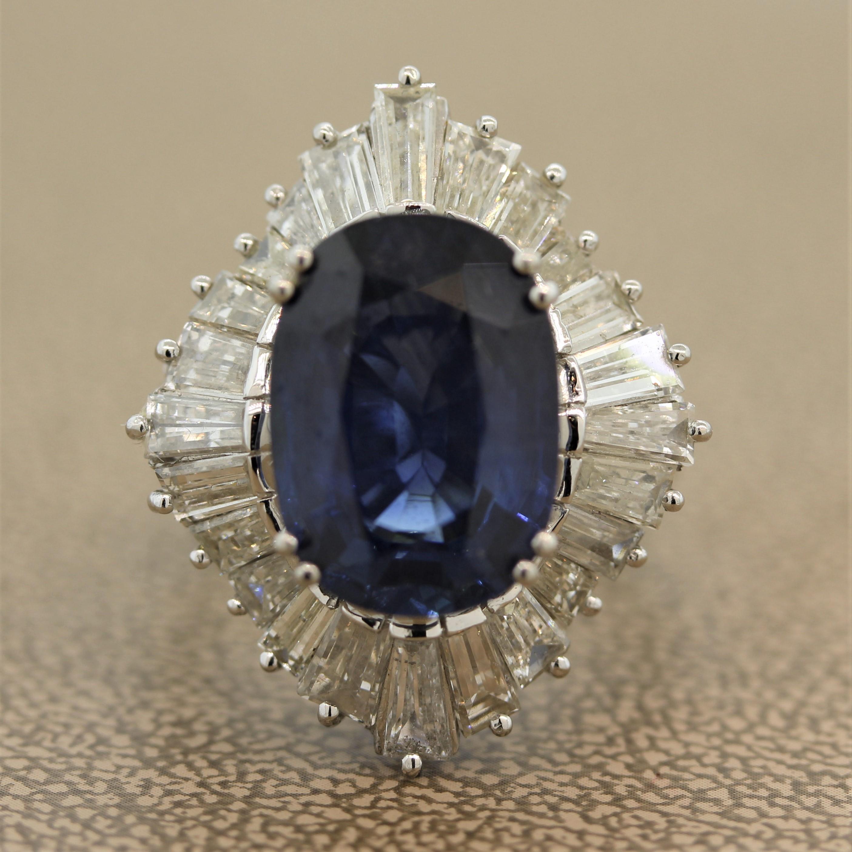 A large and luscious 8.30 carat natural blue sapphire takes center stage. It is a beautiful oval shape, a fine even blue color and no visible inclusions. It is surrounded by 3.12 carats of tapered baguette cut diamonds which spiral around the