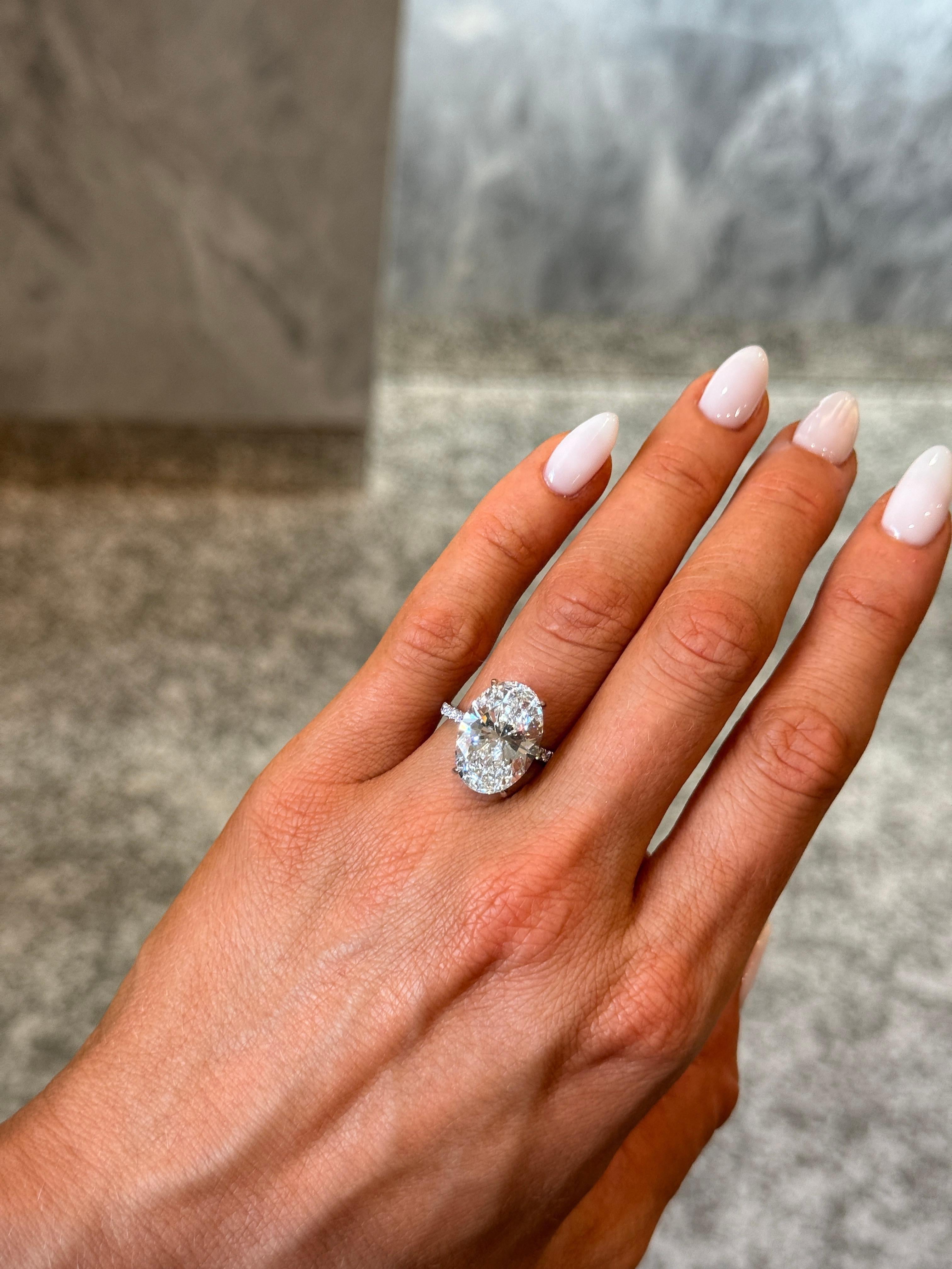 Cette magnifique bague de fiançailles est ornée d'un diamant naturel ovale brillant de 8,30ct, classé D/SI1 par le GIA - la catégorie de couleur la plus élevée, offrant une luminosité exceptionnelle et une présence blanche glacée. Le diamant