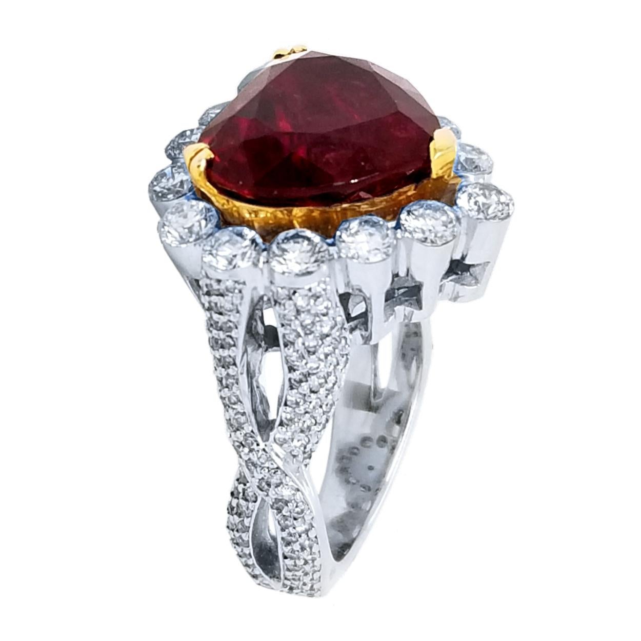 Una bellissima rubellite rosso sangue di piccione di 8,31 carati a forma di cuore incastonata al centro di un anello di diamanti invisibili/incastonati a 18 carati con un'aureola che crea un grande contrasto. 

Dettagli:
Pietra centrale: Rubellite a