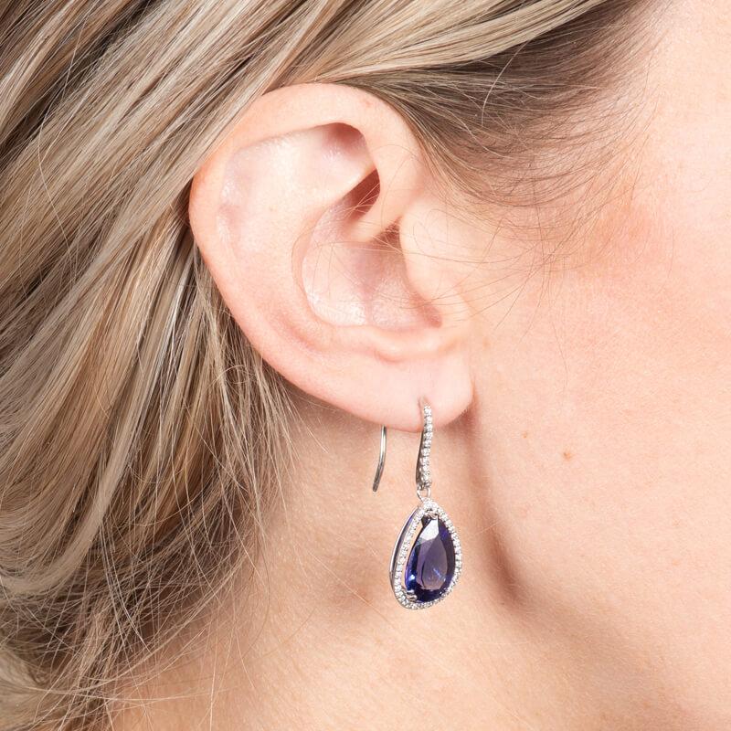 These beautiful earrings feature 8.35ct total weight in rich blue pear shaped tanzanites surrounded by a halo of 0.45ct total weight round brilliant cut diamonds. These are set in 14 karat white gold. 
Measurements: Tanzanite measures approximately