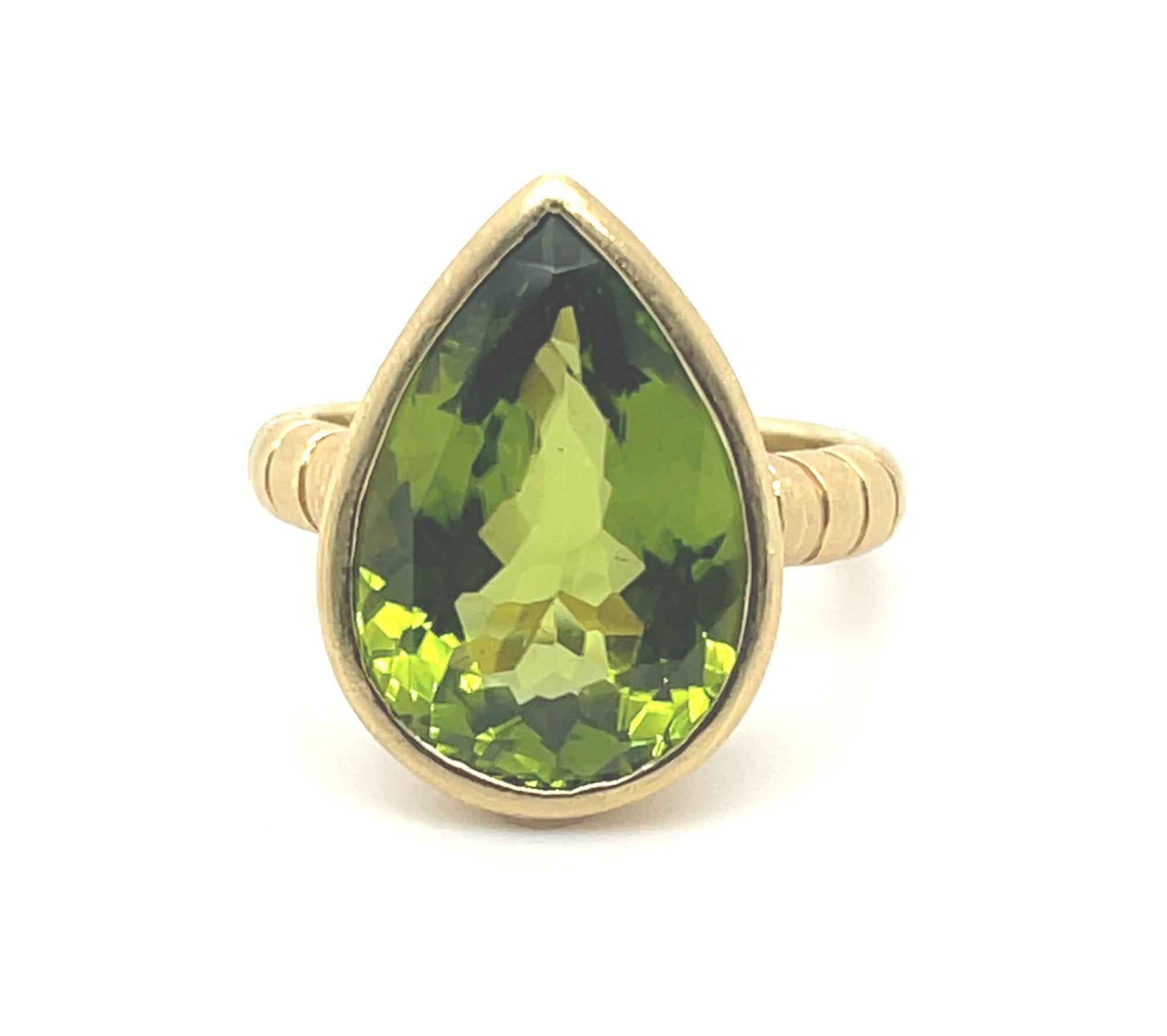 A large, luscious, lime-green peridot is featured in this ring. It is clean and bright and weighs 8.37 carats. It is bezel set in our signature brushed and engraved 18k yellow gold setting. Pear shaped peridots are not often seen, making this