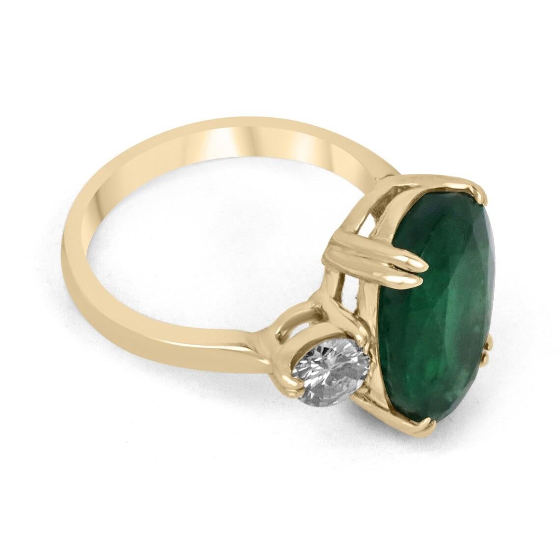 A classic emerald and diamond engagement, statement, or right-hand ring. Dexterously crafted in gleaming 14K gold this ring features a natural oval cut emerald that is set in a secure prong setting. This extraordinary emerald has a deep dark rare