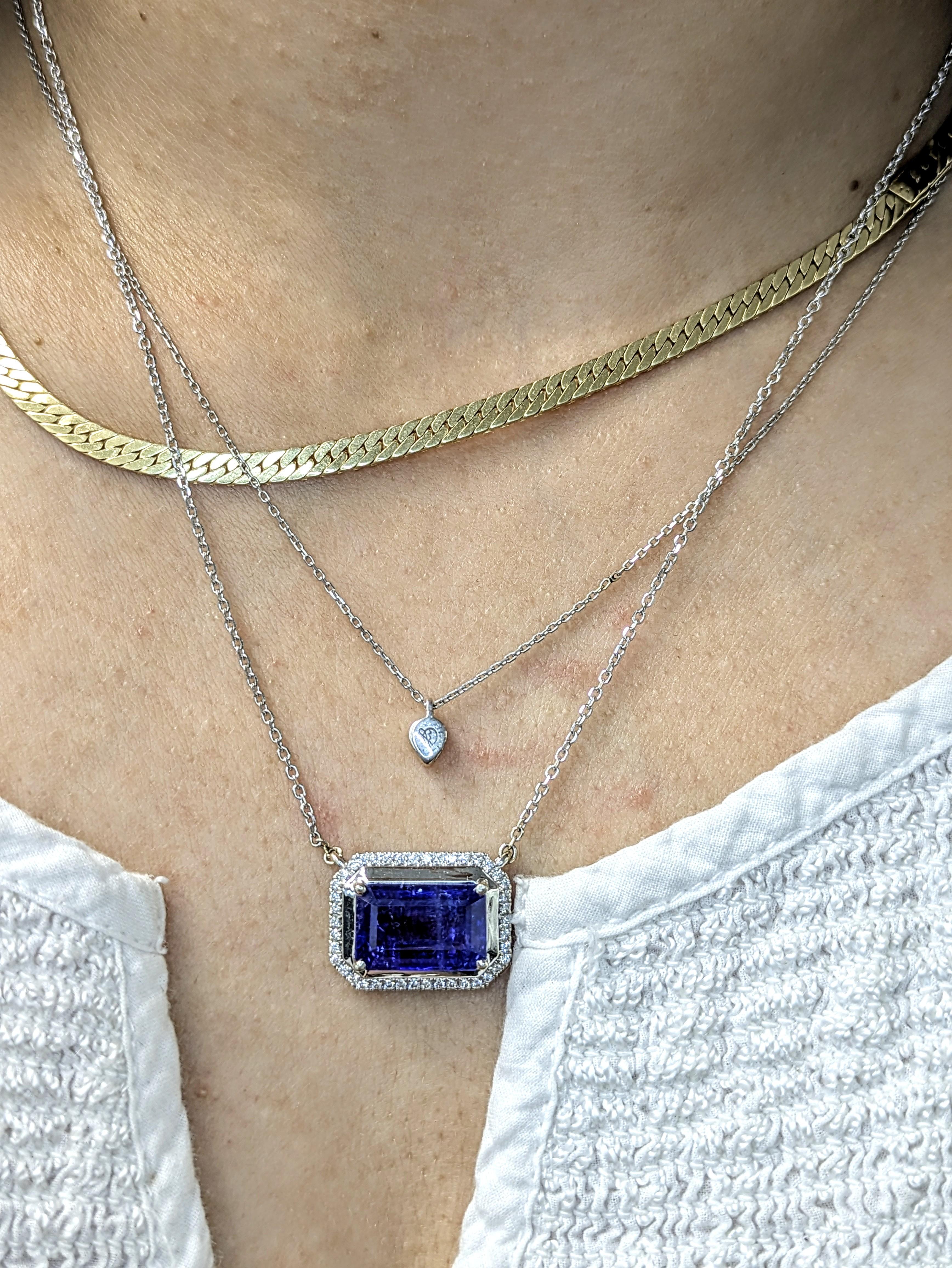 Ce grand pendentif en tanzanite est un véritable coup de cœur, avec sa pierre centrale de 8,27 carats entourée d'un halo de diamants étincelants. Fabriqué en or massif 14k et associé à une chaîne, il est conçu pour se démarquer à chaque fois qu'il