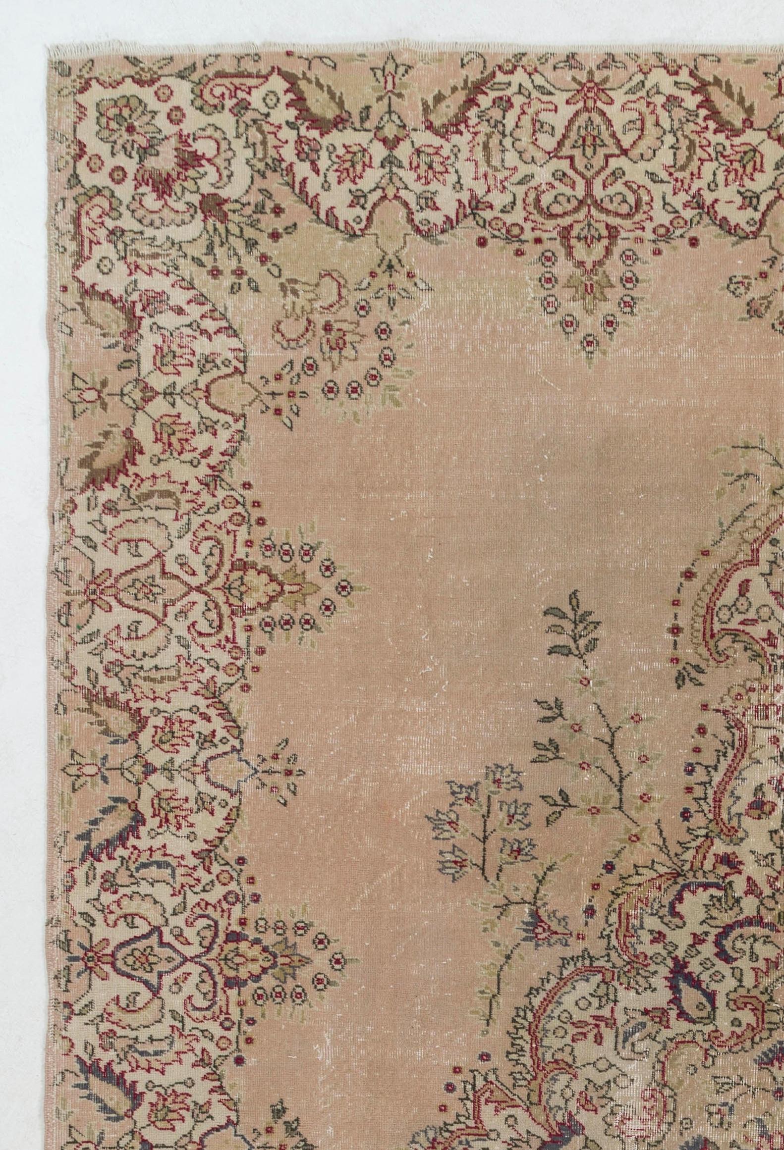 A finely hand knotted mid-20th century area rug from Western Central Turkey with a well-drawn garden design in a soft, pleasing color palette. The rug features an elegant curvilinear medallion filled with and surrounded by dainty floral vines