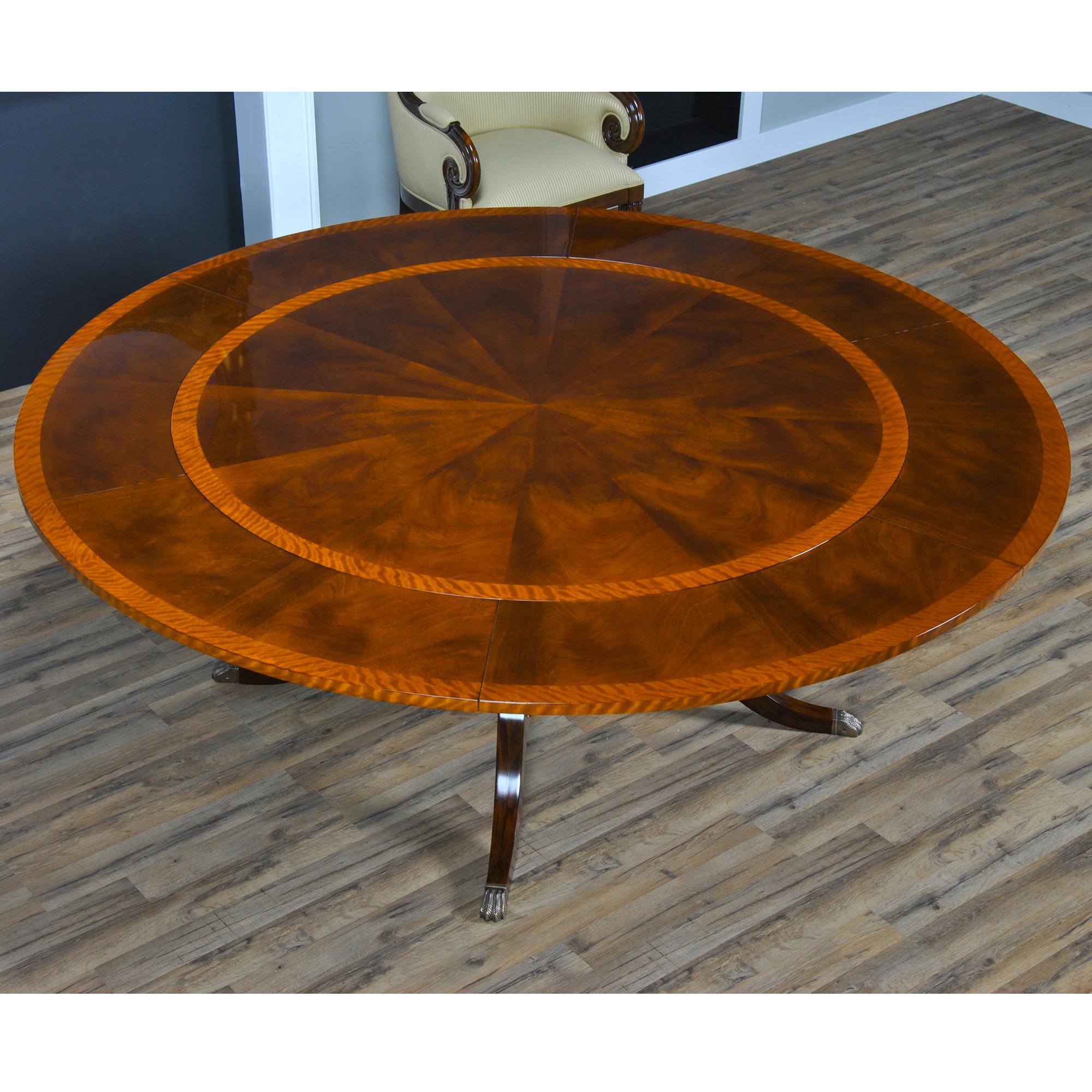 The 84 inch Round Perimeter Table is produced with a figured mahogany field and satinwood banding on the top which makes for an interesting contrast. Surrounding the 60″ round top can be placed six leaves which rest on pullout slides and are