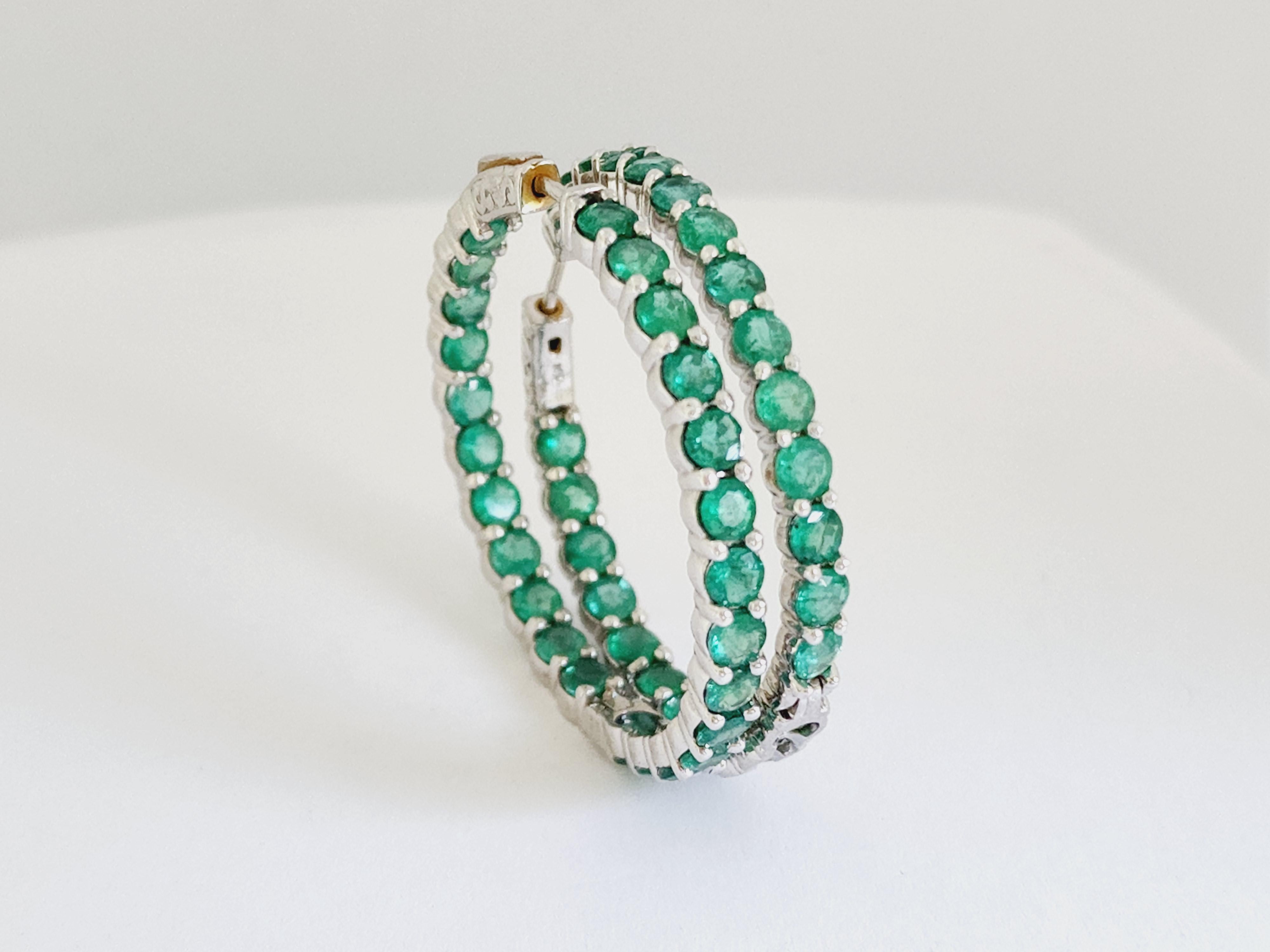Elevate your jewelry collection with these stunning 8.50 carat natural emerald hoop earrings, masterfully set in 14 karat white gold. Each round-cut emerald is carefully selected for vibrant green color and brilliance, creating a striking visual