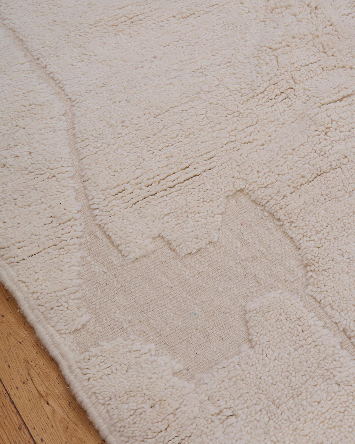 Il tappeto Amina è un lussuoso pezzo Beni Ouarain, realizzato a mano da abili artigiani berberi nelle montagne dell'Atlante in Marocco. Realizzato al 100% in lana naturale di pecora, questo tappeto presenta un vello spesso e felpato che offre calore