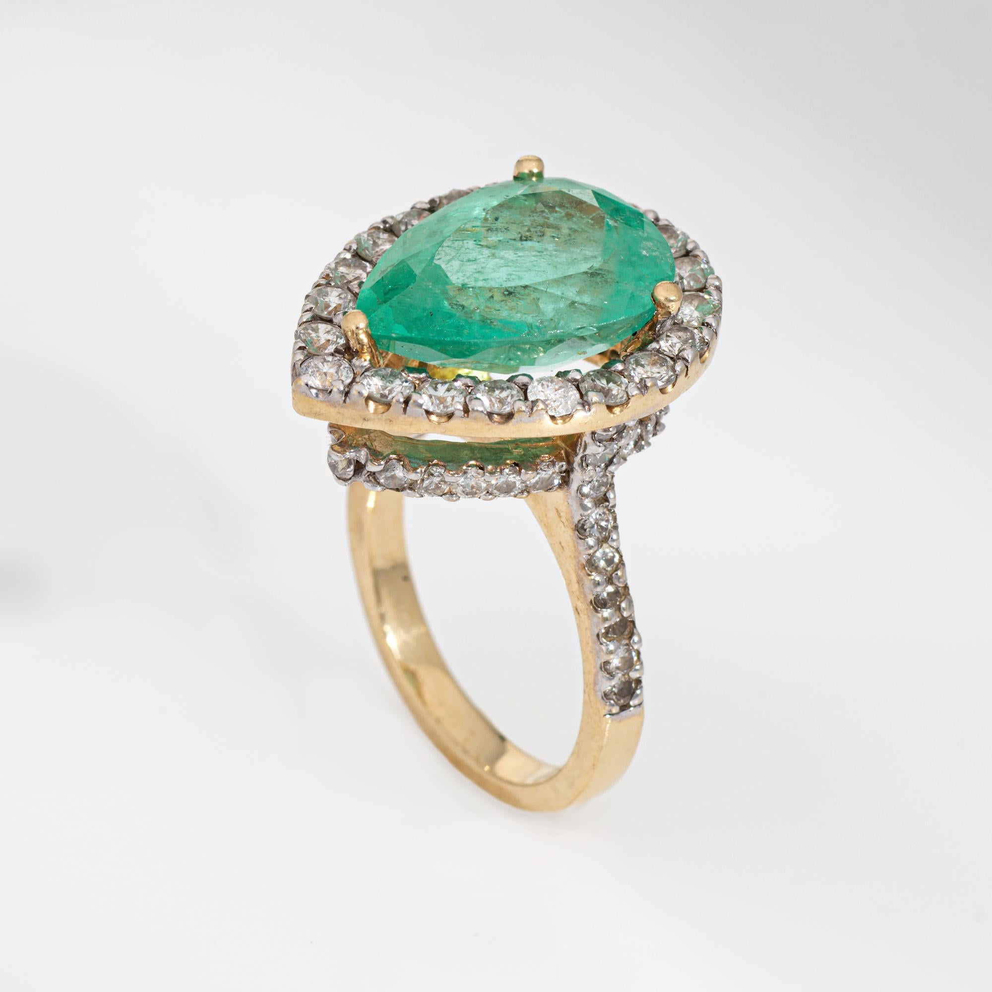 Stylish vintage emerald & diamond cocktail ring crafted in 14 karat yellow gold (circa 1980s to 1990s). 

Pear cut natural emerald measures 17mm x 12mm x 8.40mm (estimated at 8.445 carats). The emerald is moderately included, type III, moderately