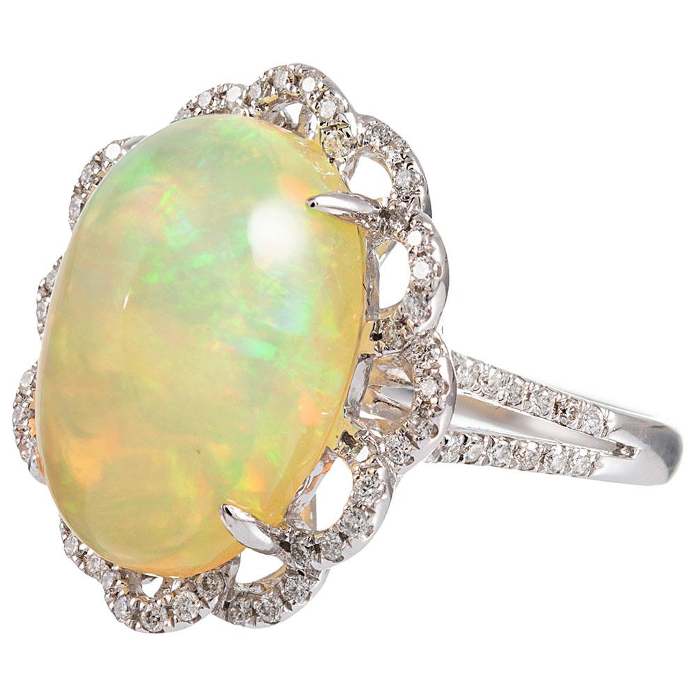 An 8.46 cabochon of opal is set in a mounting of 14 karat white gold with a diamond lace skirt framing its border. The luminescent glow of the stone will draw your eye closer, so you may appreciate its charm. The ring is appointed with .60 carats of