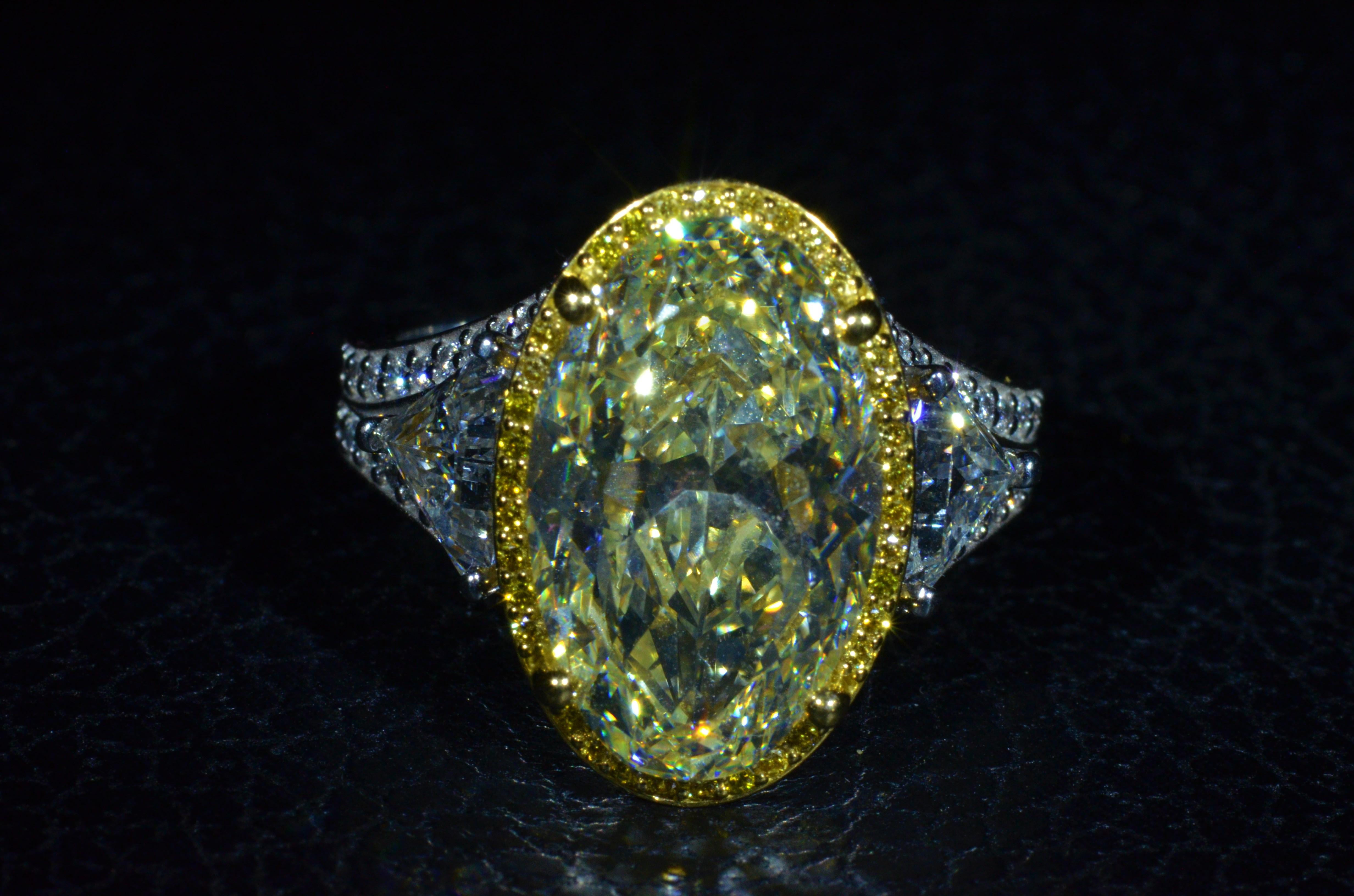 Ladies Platinum and 18 Karat Yellow gold ring set with a 8.48 Carat center oval brilliant cut diamond.  The diamond has a Gemological Institute of America clarity grade of VVS2 and a color grade of Y-Z for the fancy light yellow look.  Surrounding