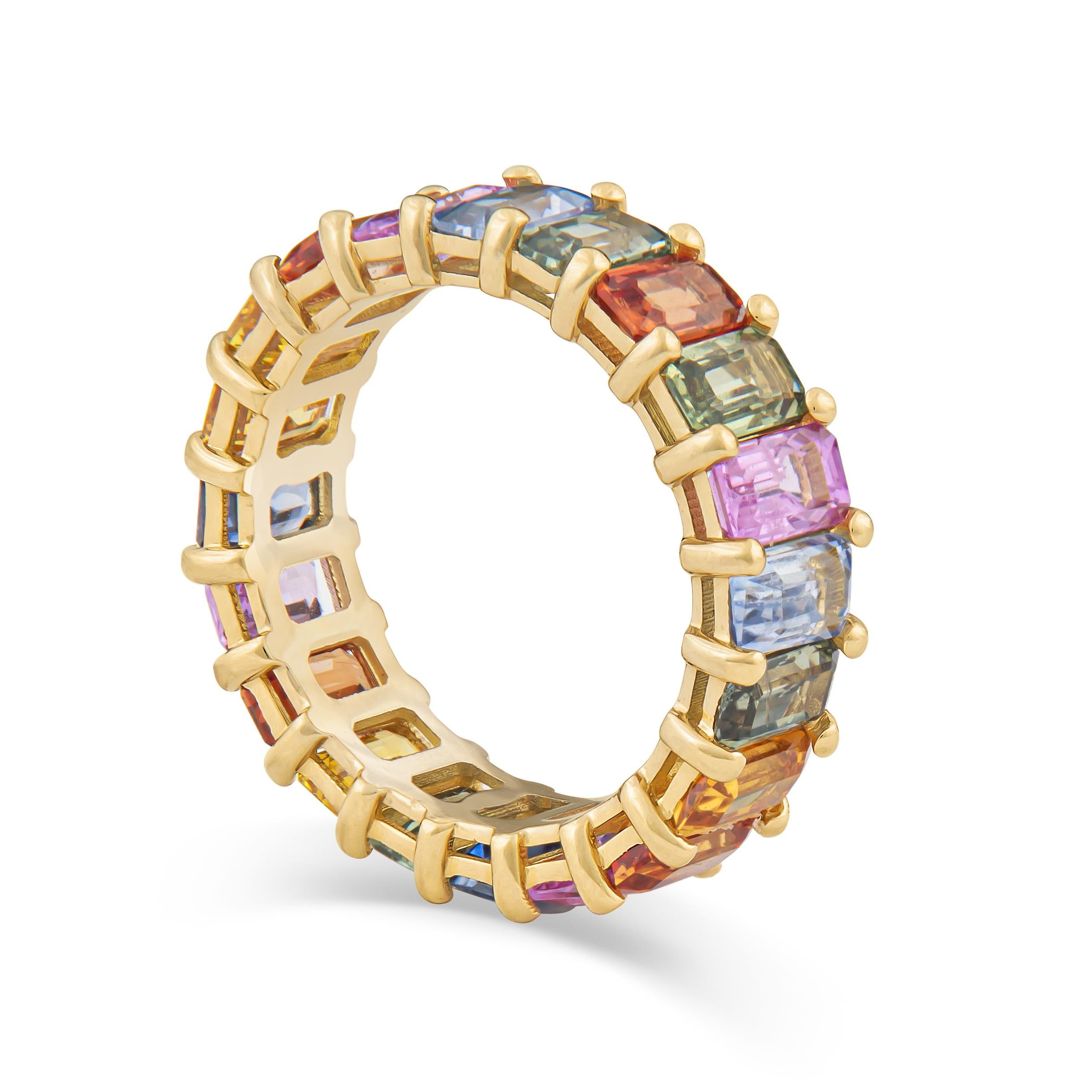 A beautiful and fashionable eternity band set in 18 karat rose gold features a total of 7.93 carats of multi colored emeralds.  This band was crafted in house.  The overall diameter of the band measures 5.80mm. 